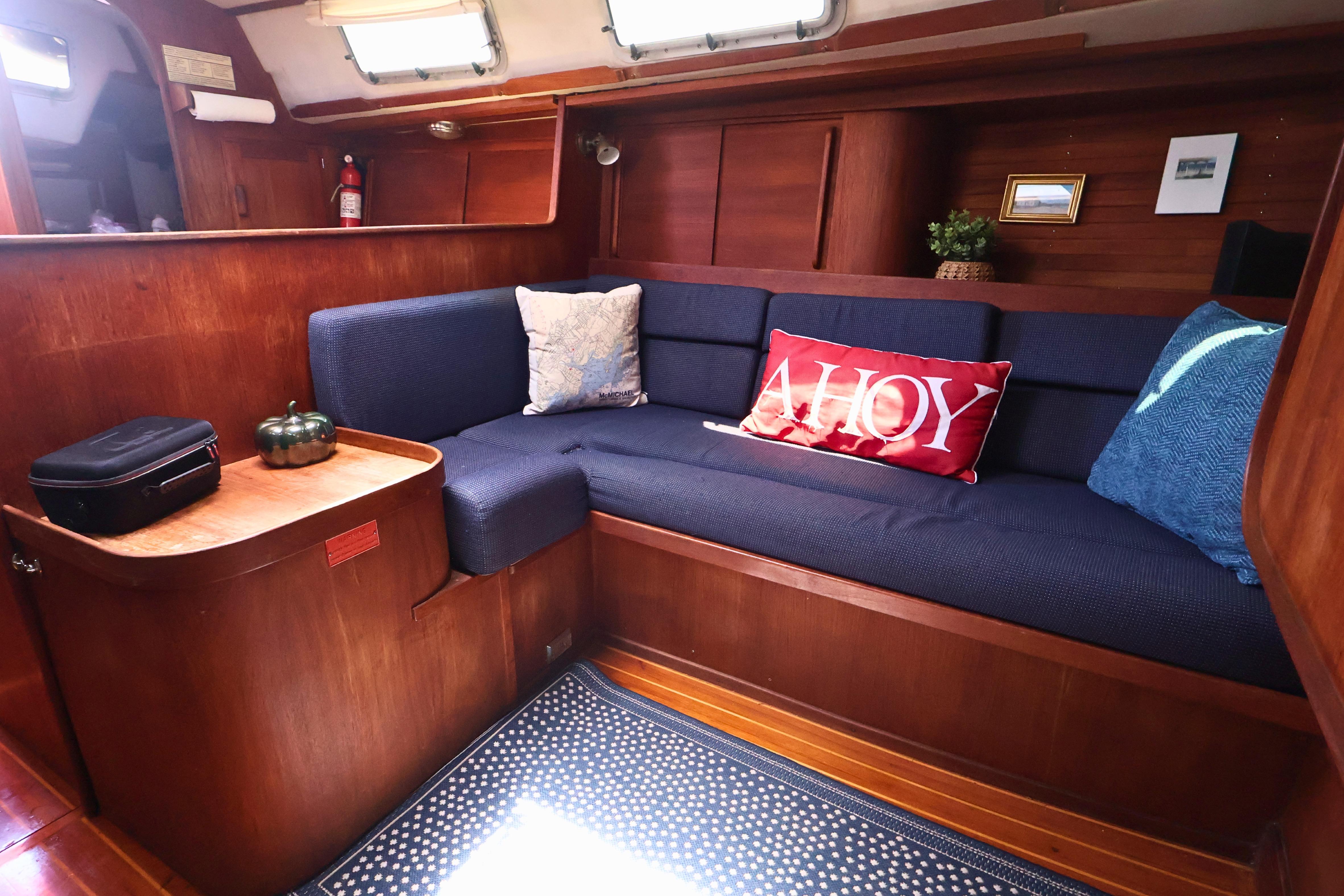 Cozy interior of 1989 J Boat J 40 with blue seating and nautical decor.