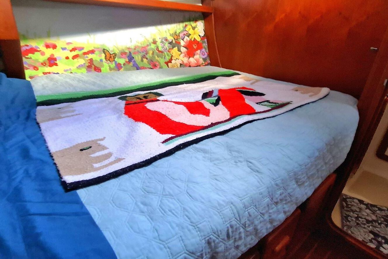 Cozy cabin bed in 1997 Caliber 47LRC with colorful bedding and floral decor.