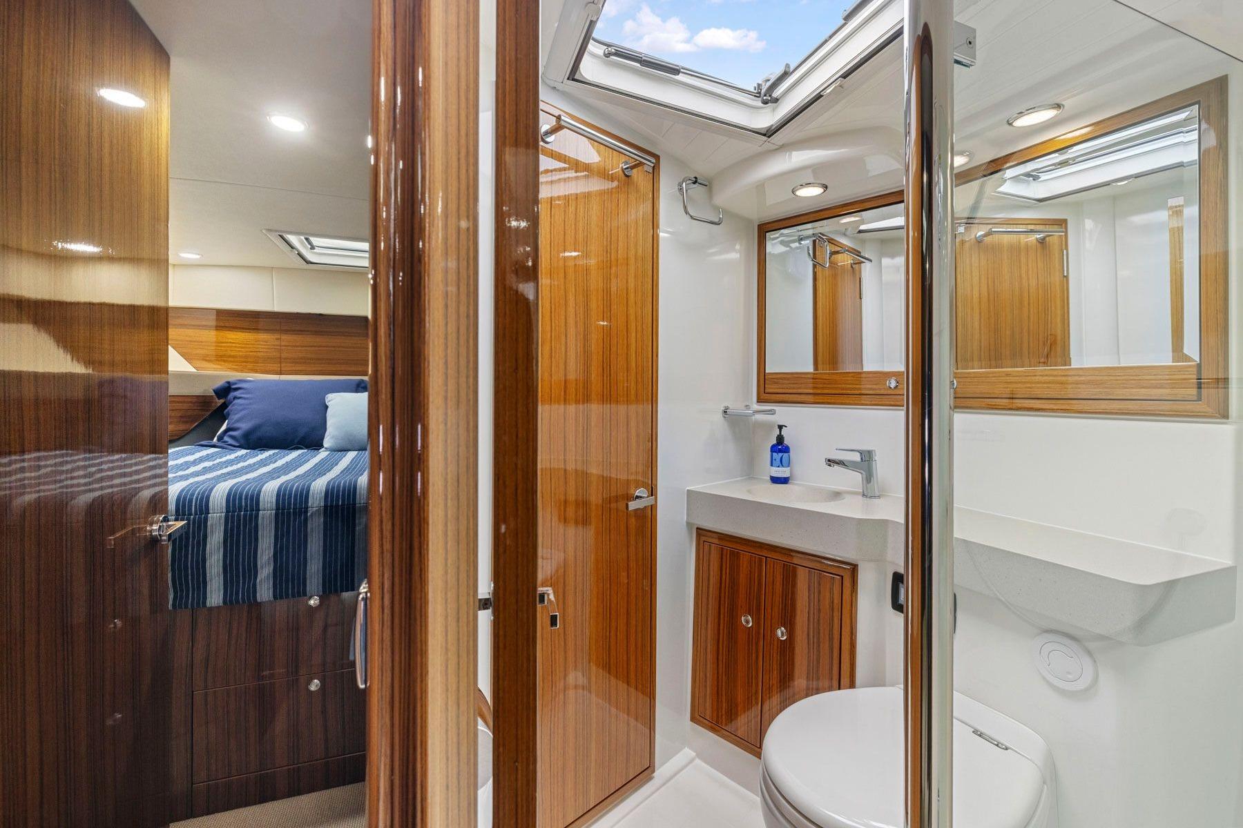 Luxurious 2014 Maritimo M50 yacht interior with wood accents and modern bathroom.