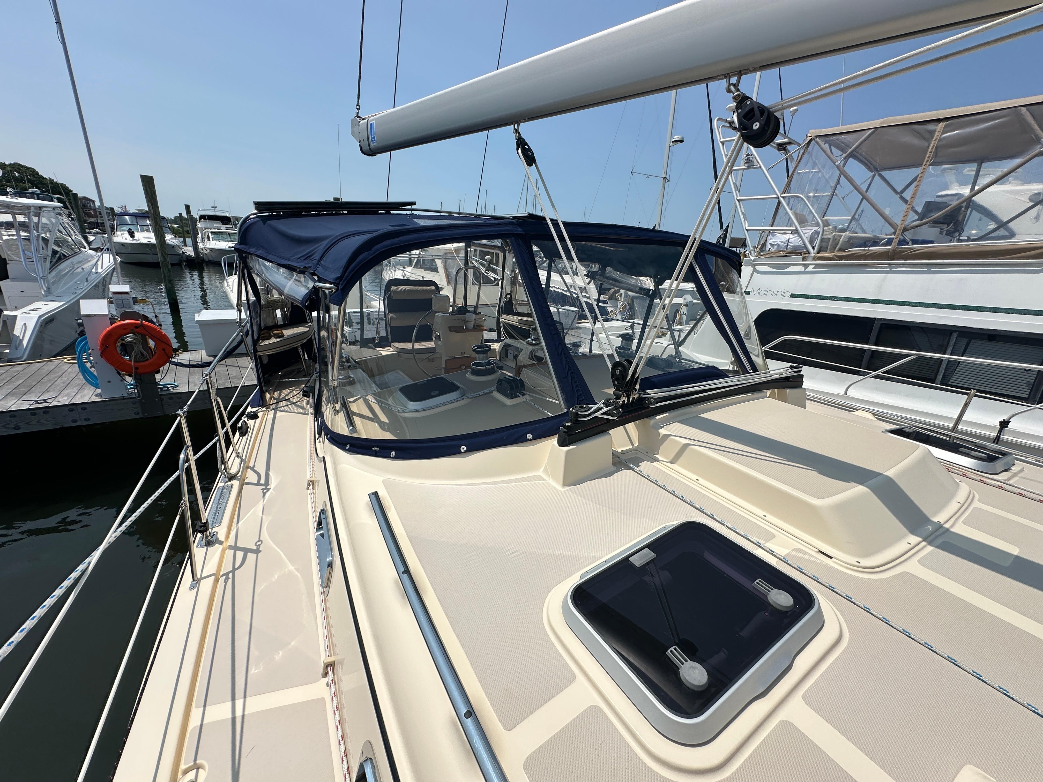 2021 Island Packet 439 sailboat docked, featuring a sleek deck and blue canopy.