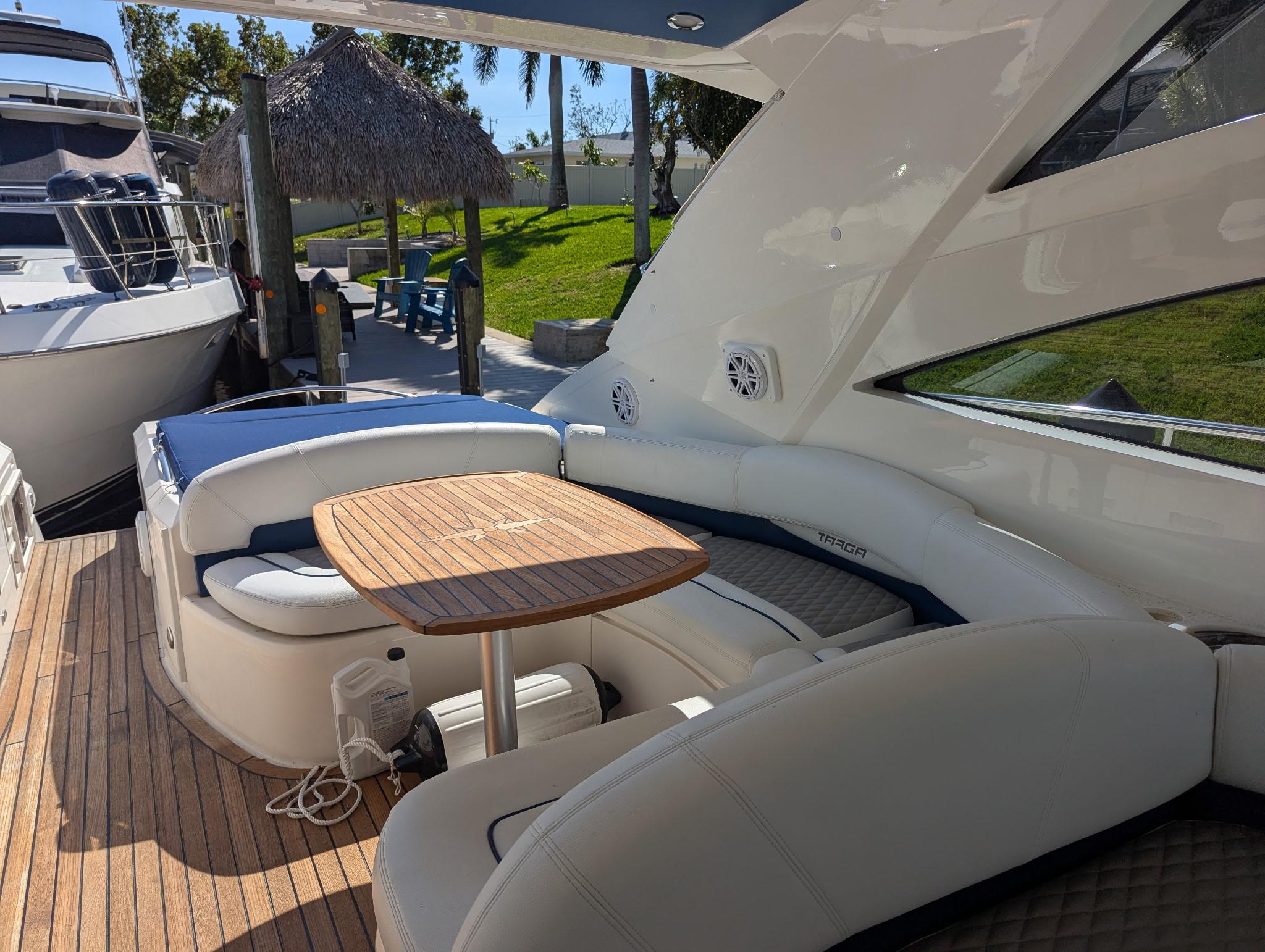 2007 Fairline Targa 52 GT yacht with elegant seating and wooden table on deck.
