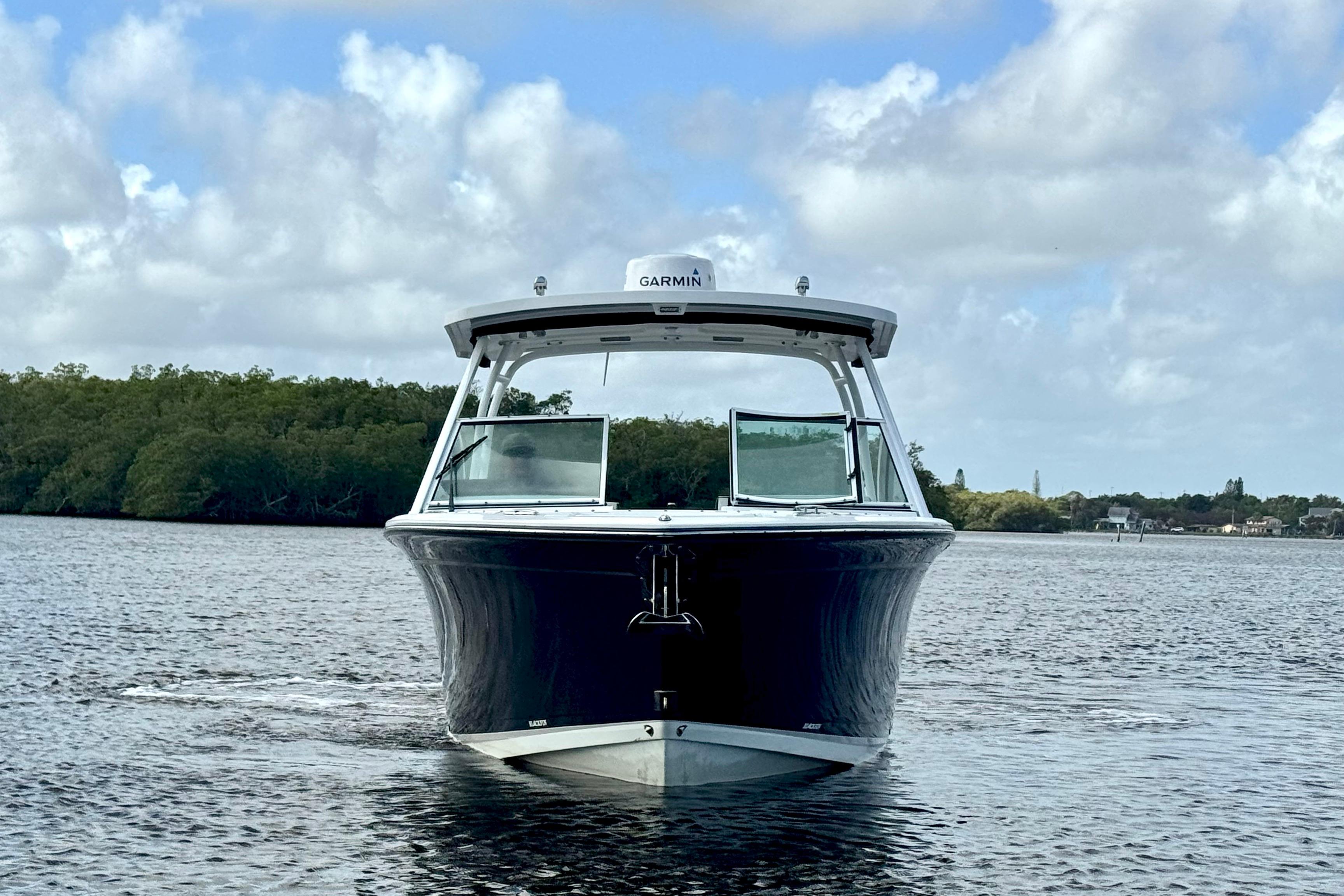 2023 Blackfin 272 DC boat on water, front view, under cloudy sky.