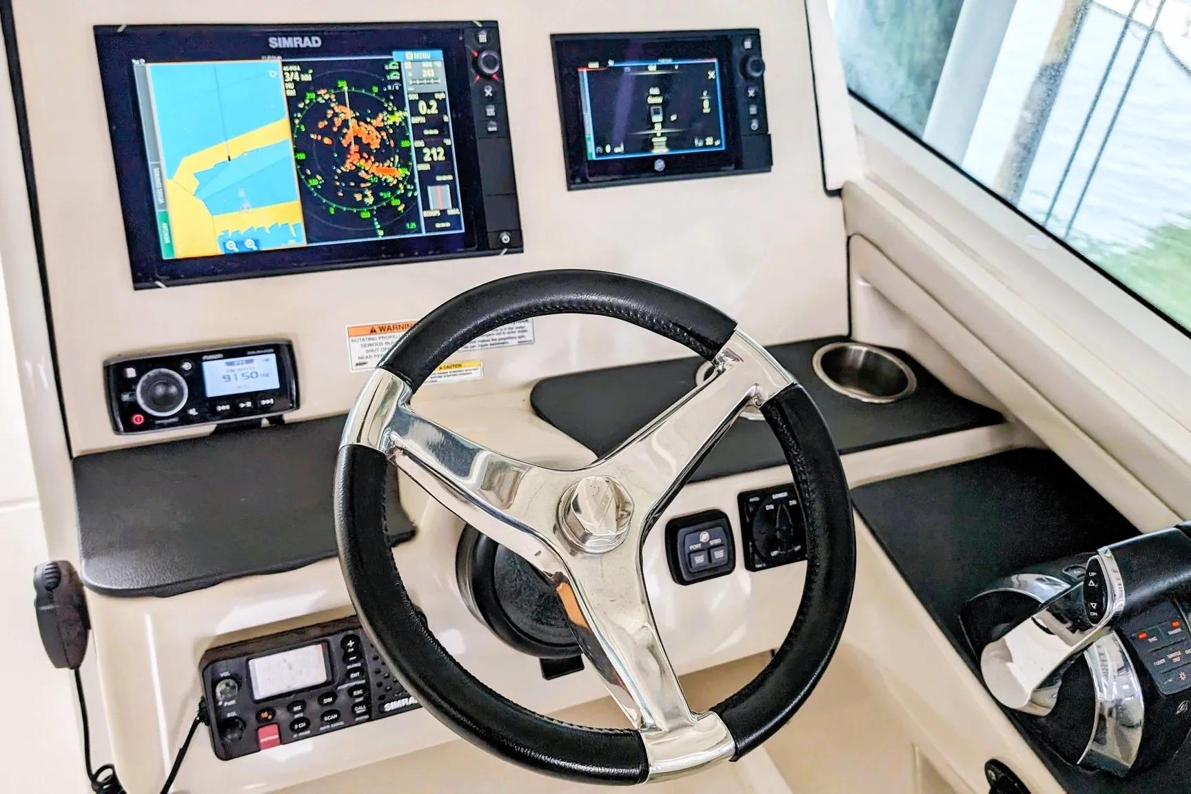 Cockpit of 2017 Boston Whaler 320 Vantage with navigation screens and steering wheel.