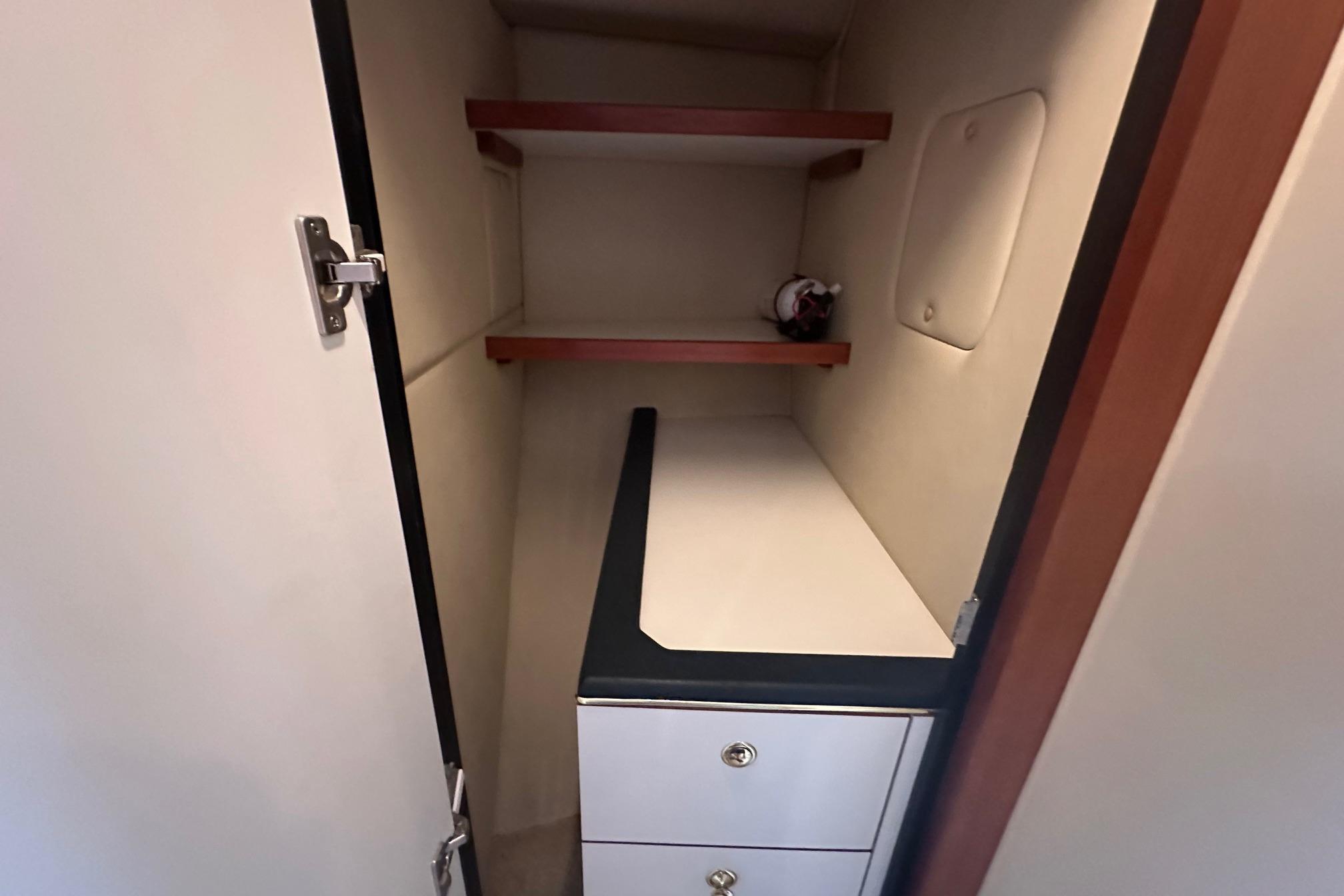 Interior storage space of 2001 Sea Ray 410 Sundancer yacht with shelves and drawers.