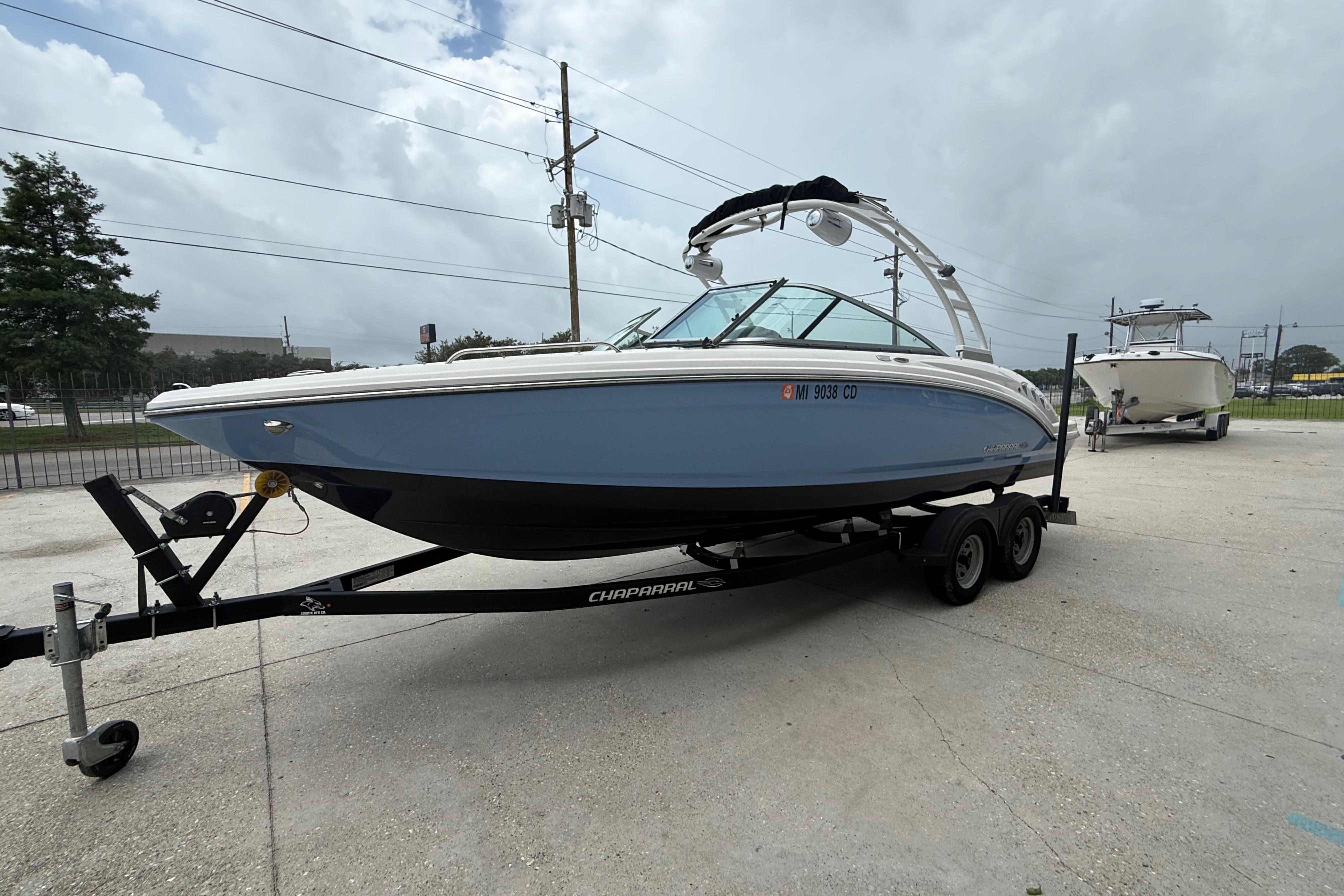 2023 Chaparral 230 SSi boat on trailer, parked outdoors under cloudy sky.
