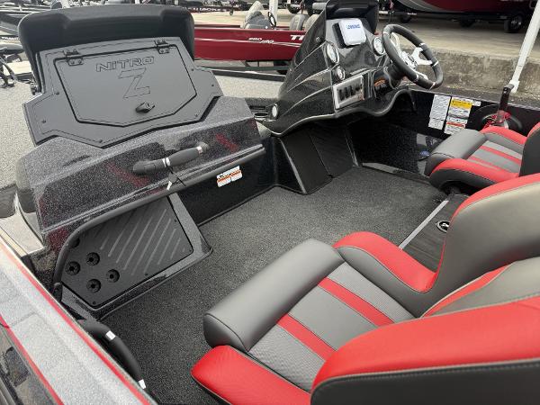 2025 Nitro Z19 boat interior with red and gray seating, steering console, and storage compartments.