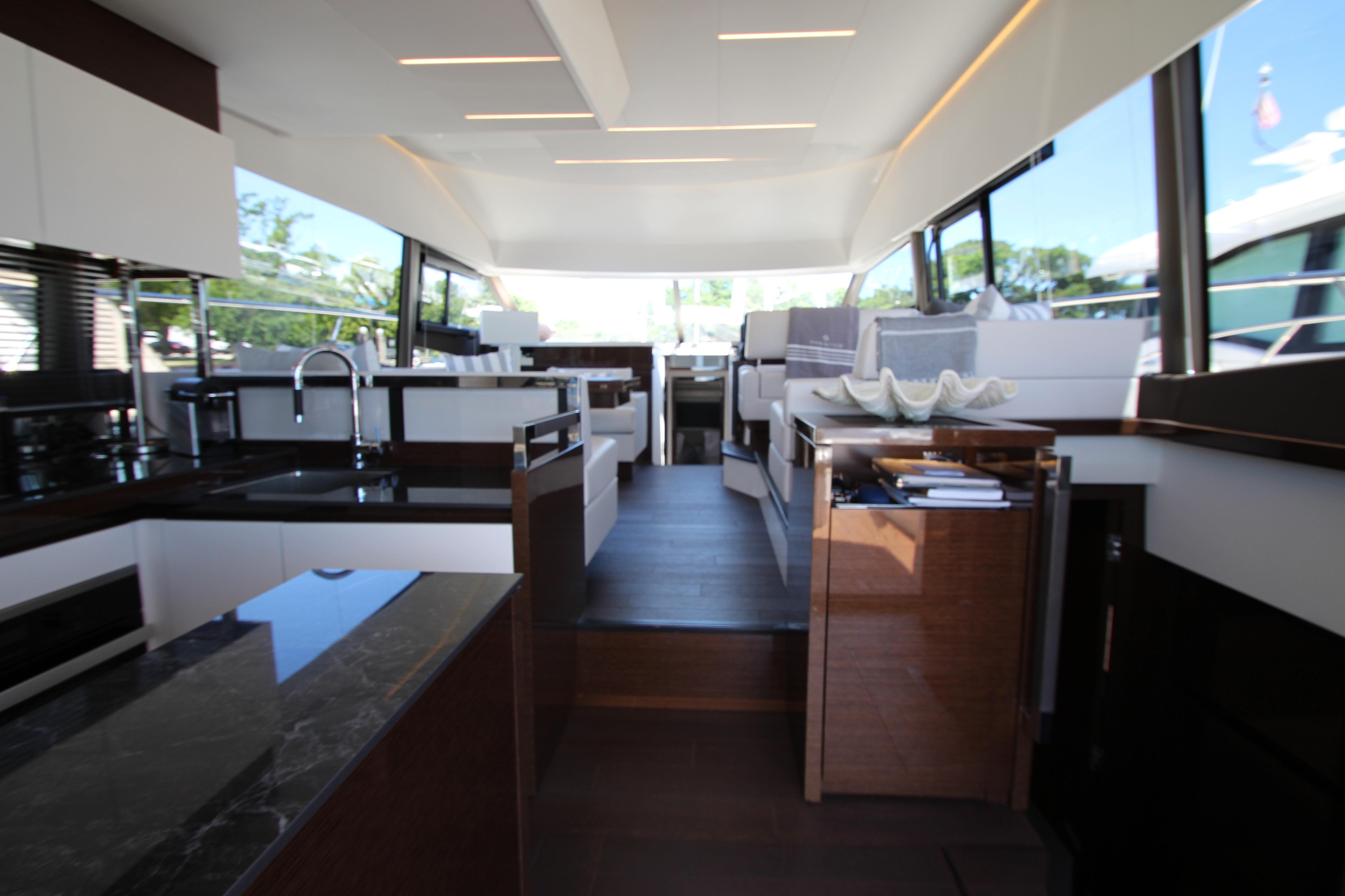 Luxurious interior of 2022 Prestige 520 yacht with modern kitchen and seating area.