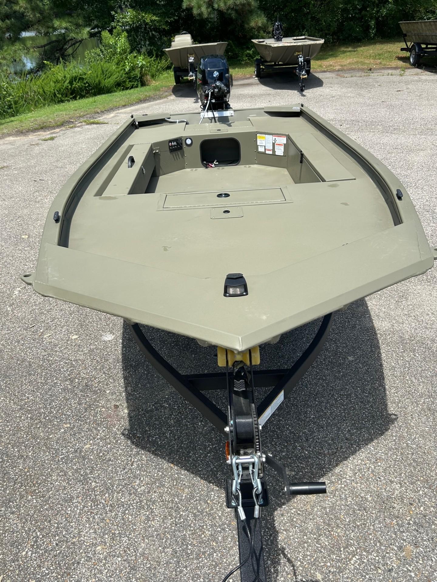 2025 Tracker Grizzly 1654 T Sportsman boat on trailer, parked outdoors.