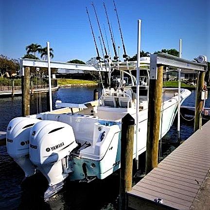 A 2019 Sailfish 290 CC with twin Yamaha engines, docked at a calm waterway.