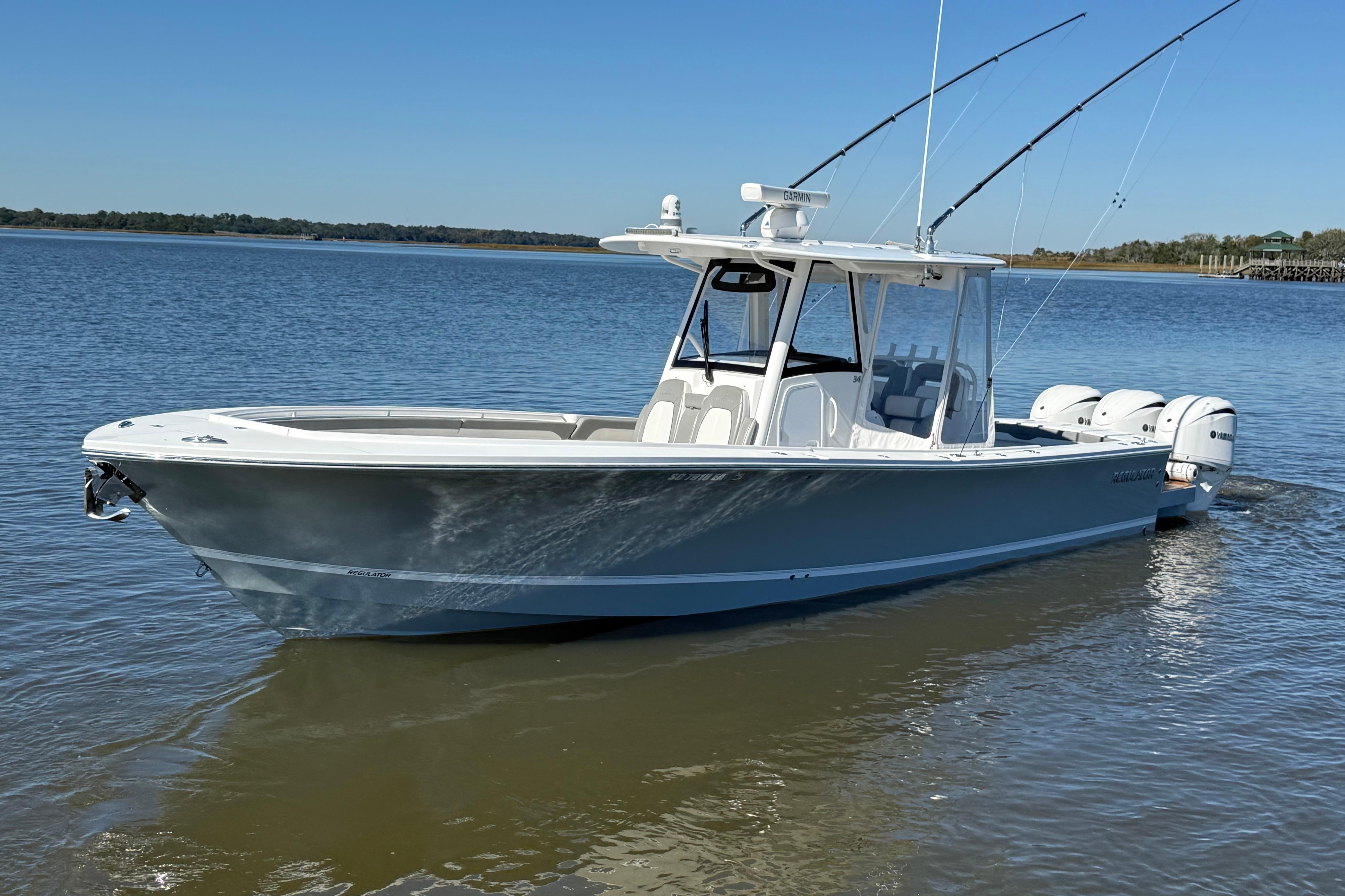 2022 Regulator 34 boat on calm water, featuring triple outboard engines.