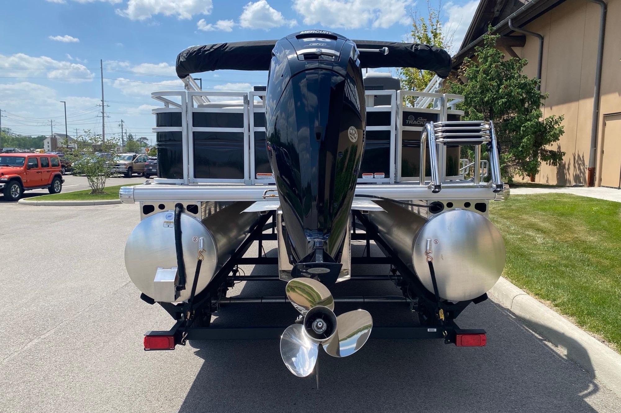 2026 Sun Tracker Fishin' Barge 20 DLX pontoon boat with powerful outboard motor.
