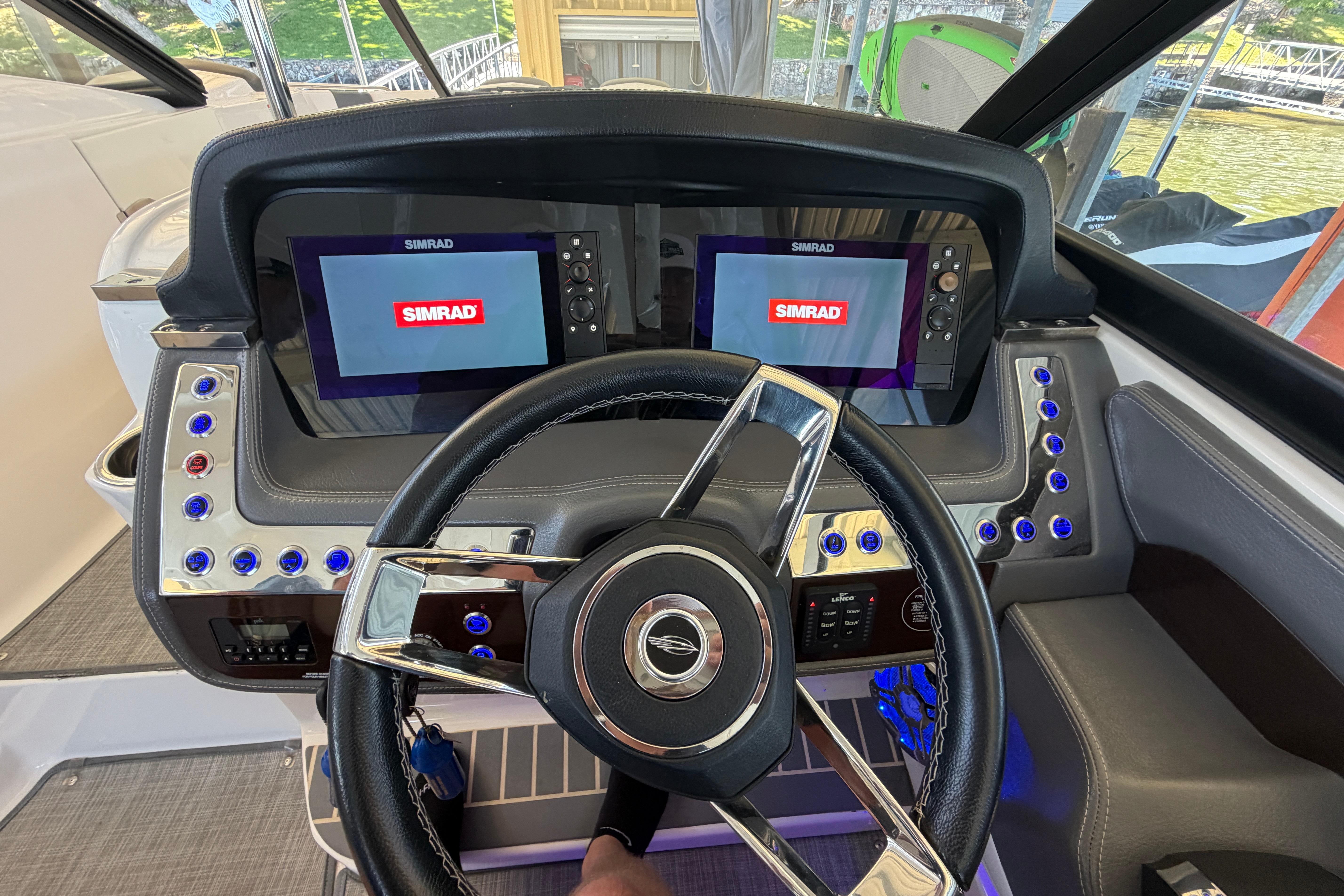 Steering wheel and dashboard of 2018 Chaparral 347 SSX boat with Simrad displays.