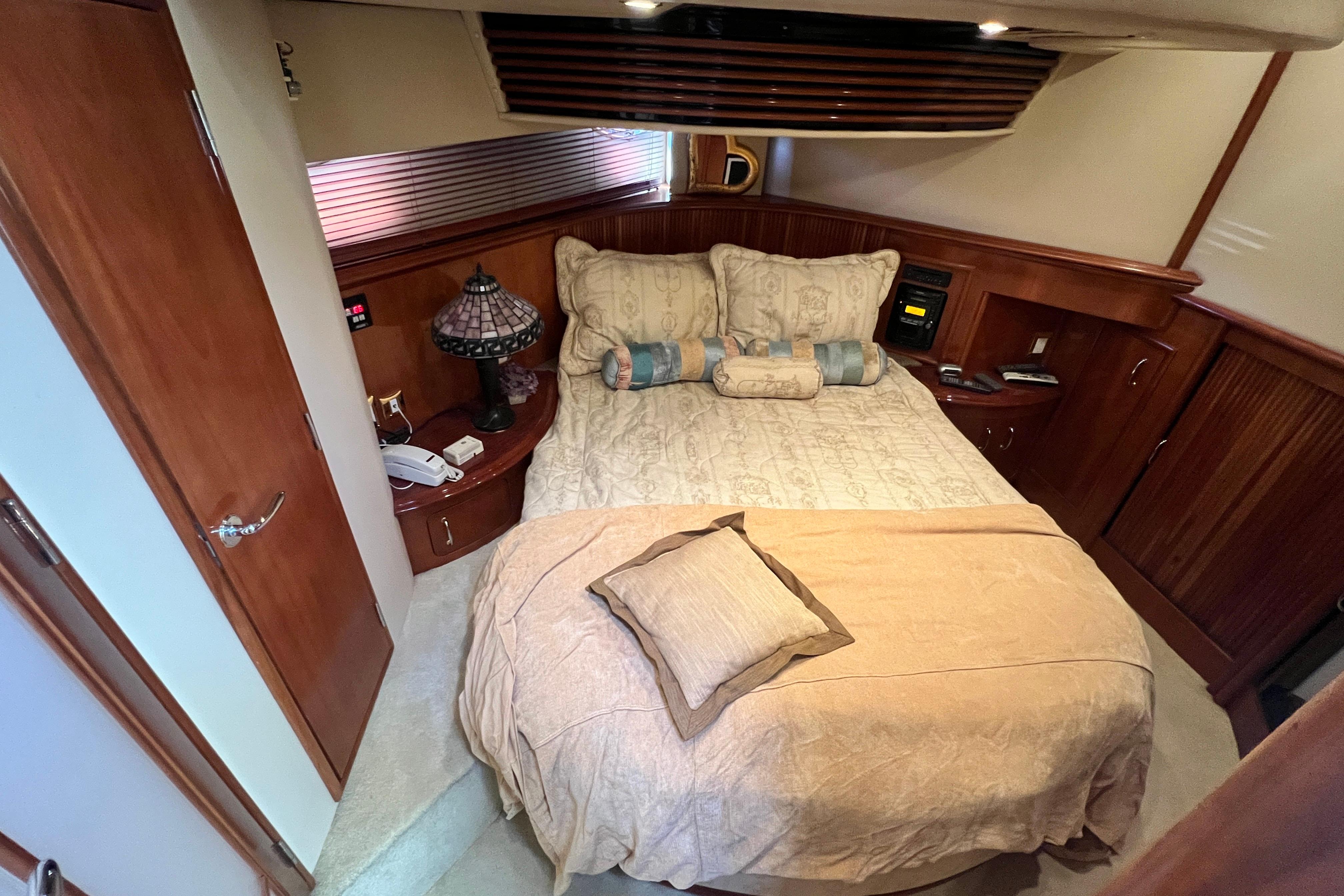 Luxurious bedroom interior of 2003 Carver 450 Voyager Pilothouse yacht with elegant wood finishes.