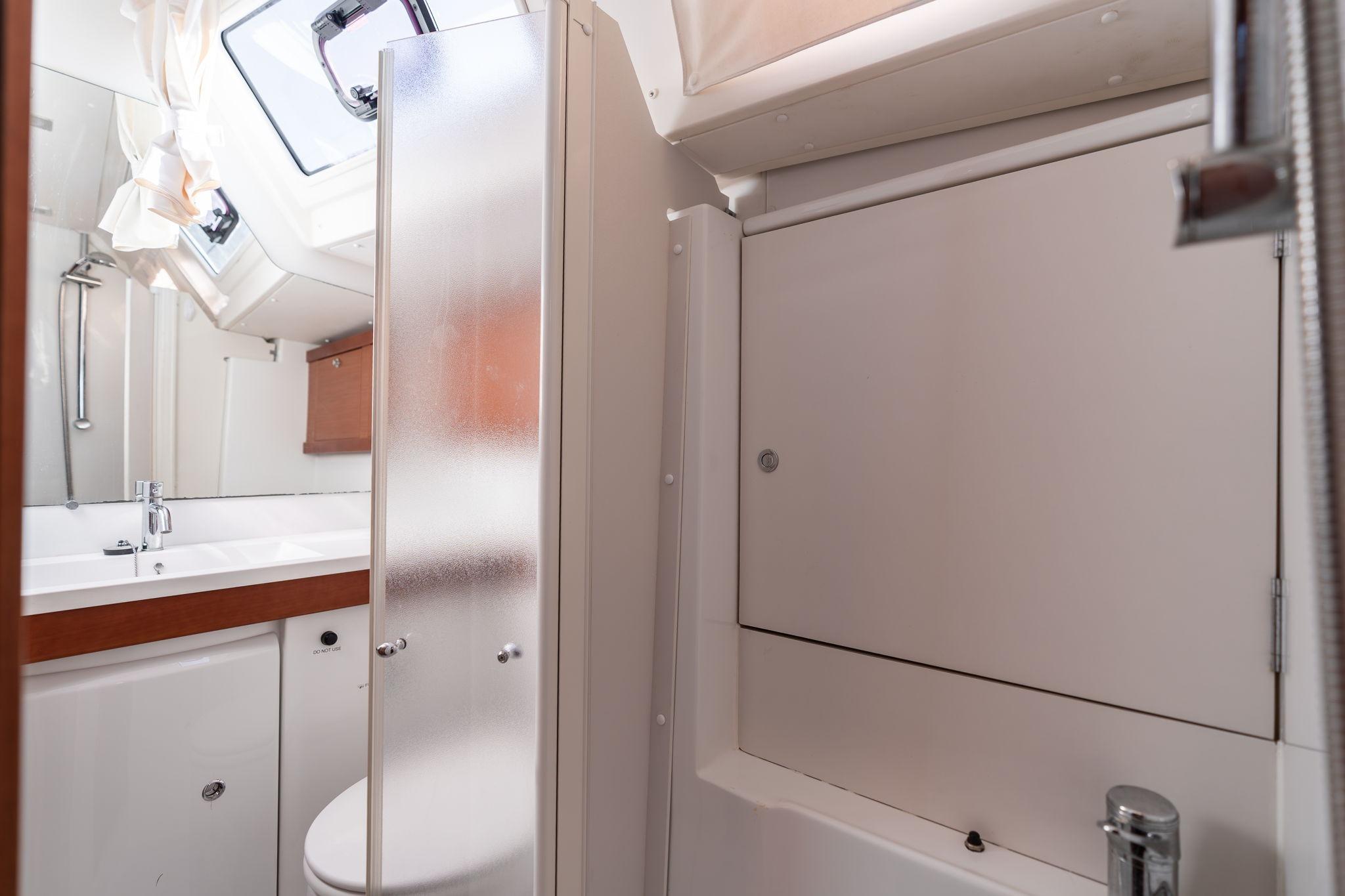Bathroom interior of 2013 Beneteau Oceanis 50 yacht, featuring modern fixtures and frosted glass.