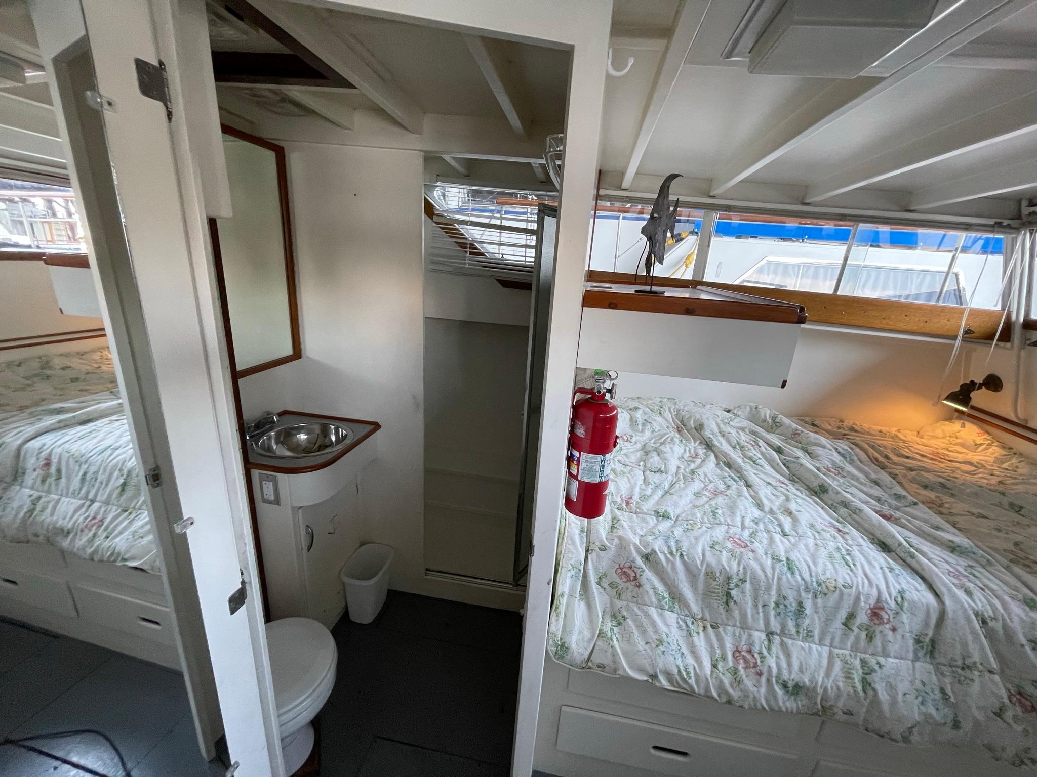 1961 Chris-Craft Conqueror cabin interior with bed, sink, and toilet.