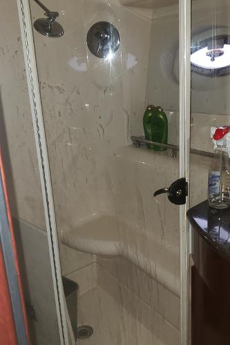 Shower area in 2010 Meridian 441 Sedan yacht with glass door and porthole.