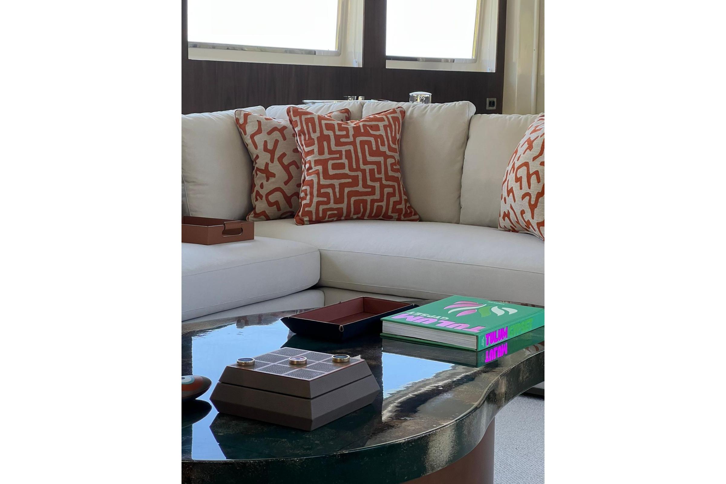 Luxurious yacht interior with patterned cushions, modern decor, and a glossy coffee table. Crestitalia 33m, 1991.
