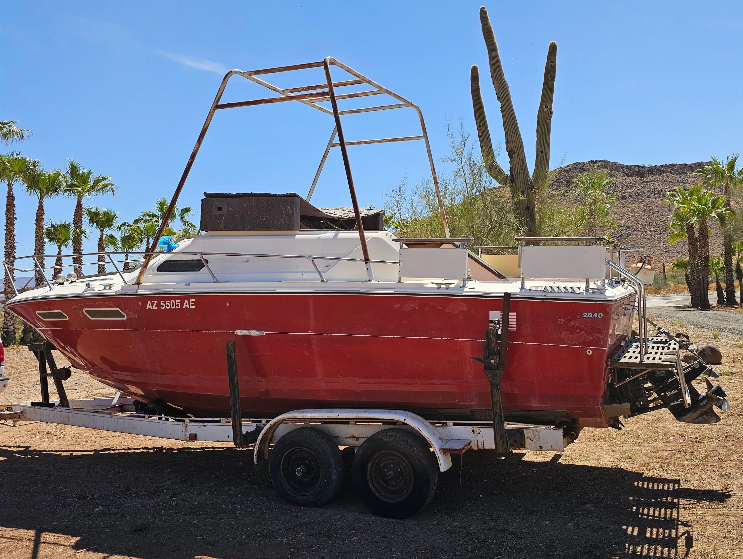 1975 Sea Ray Cabin Cruiser on trailer in desert landscape.