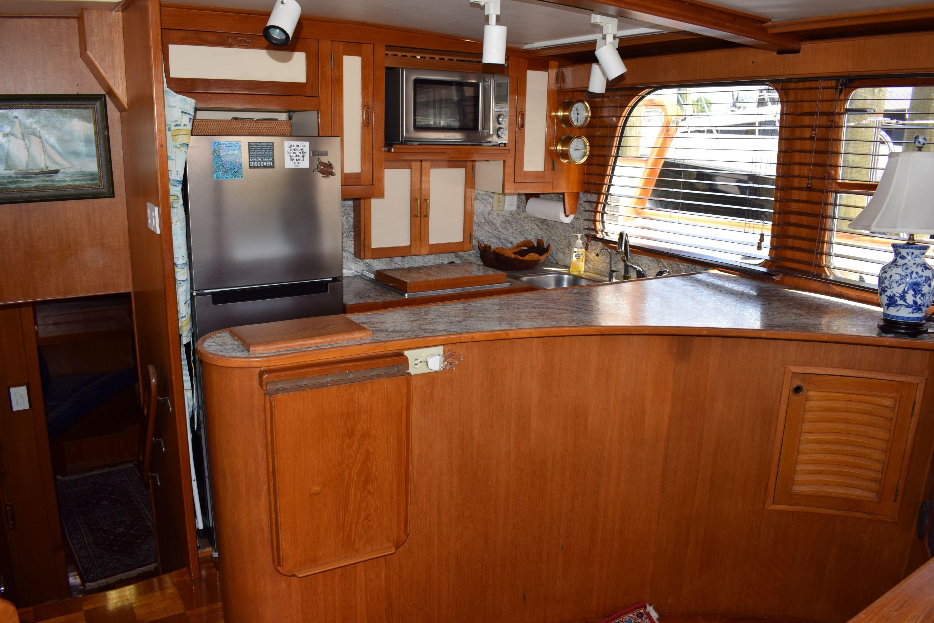 1980 Cheoy Lee 52 Motorsailer interior kitchen with wood cabinetry and modern appliances.