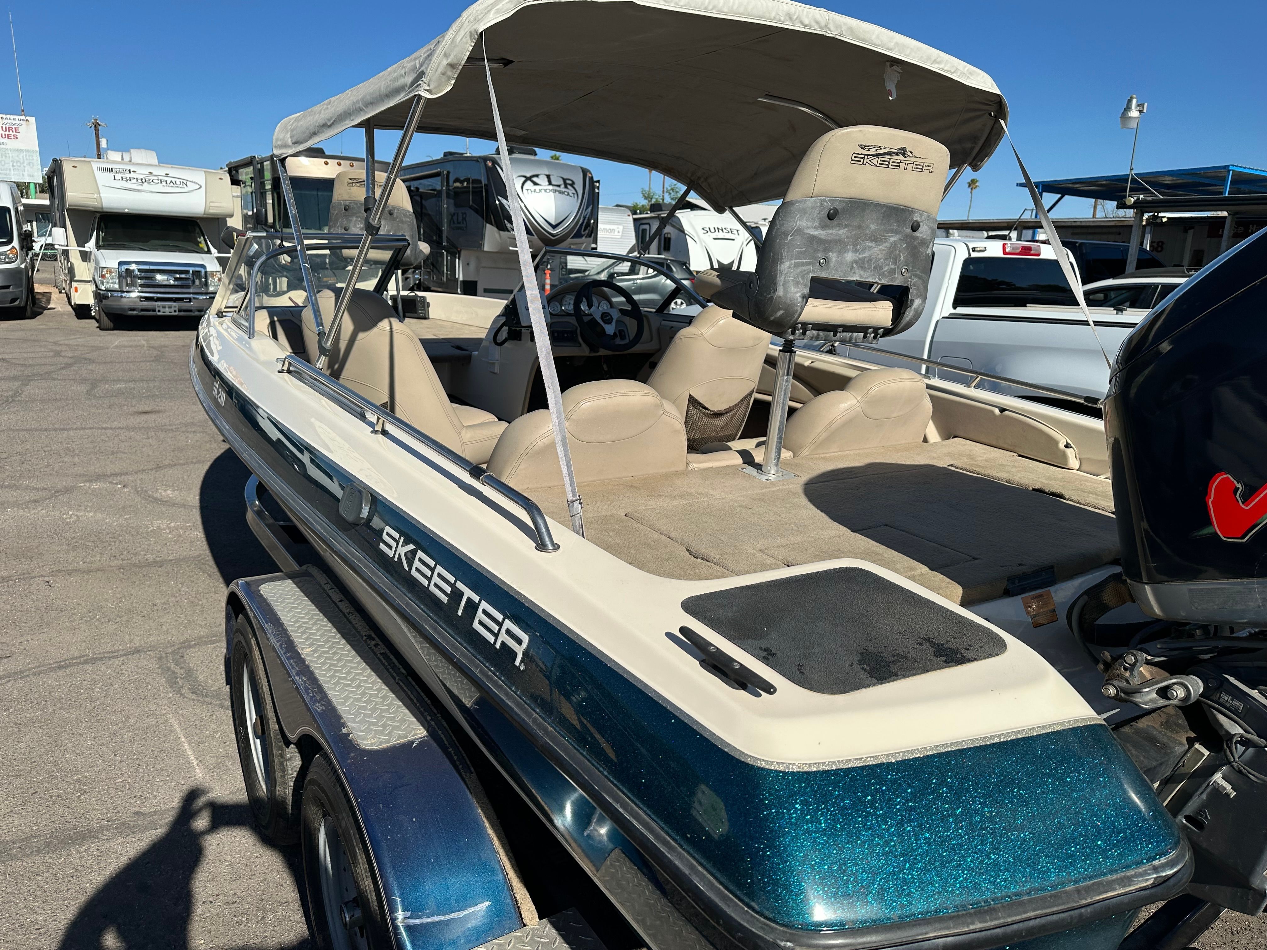 A 2008 Skeeter SL 210 boat on a trailer, featuring a blue hull and beige interior.