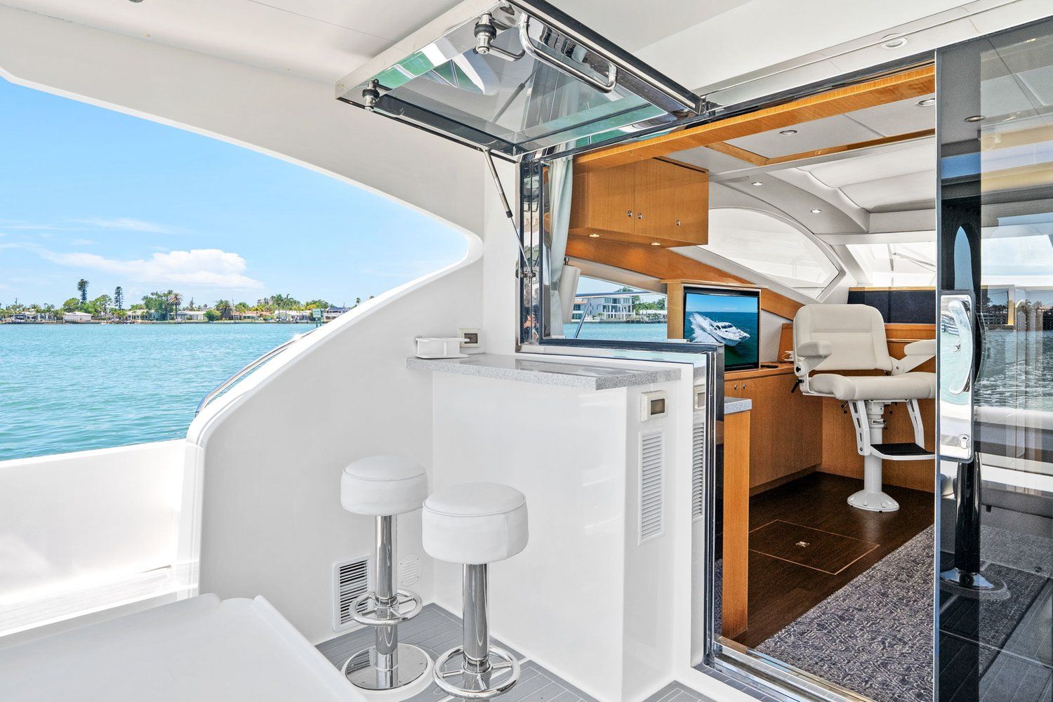 Interior of a luxury catamaran yacht with bar stools and a view of the water.