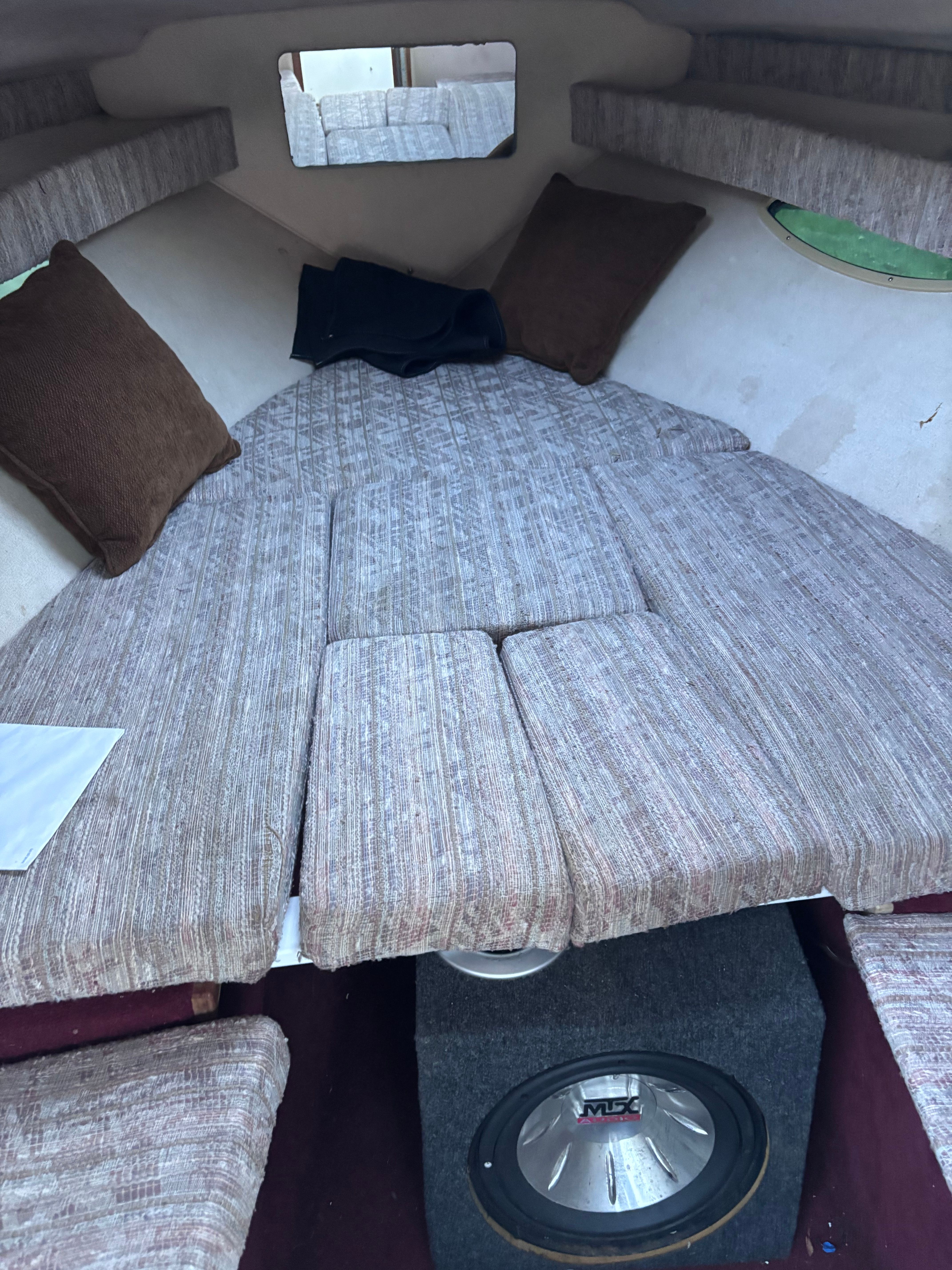 Interior of a 1989 Sea Ray Sundancer with cushioned seating and a speaker.