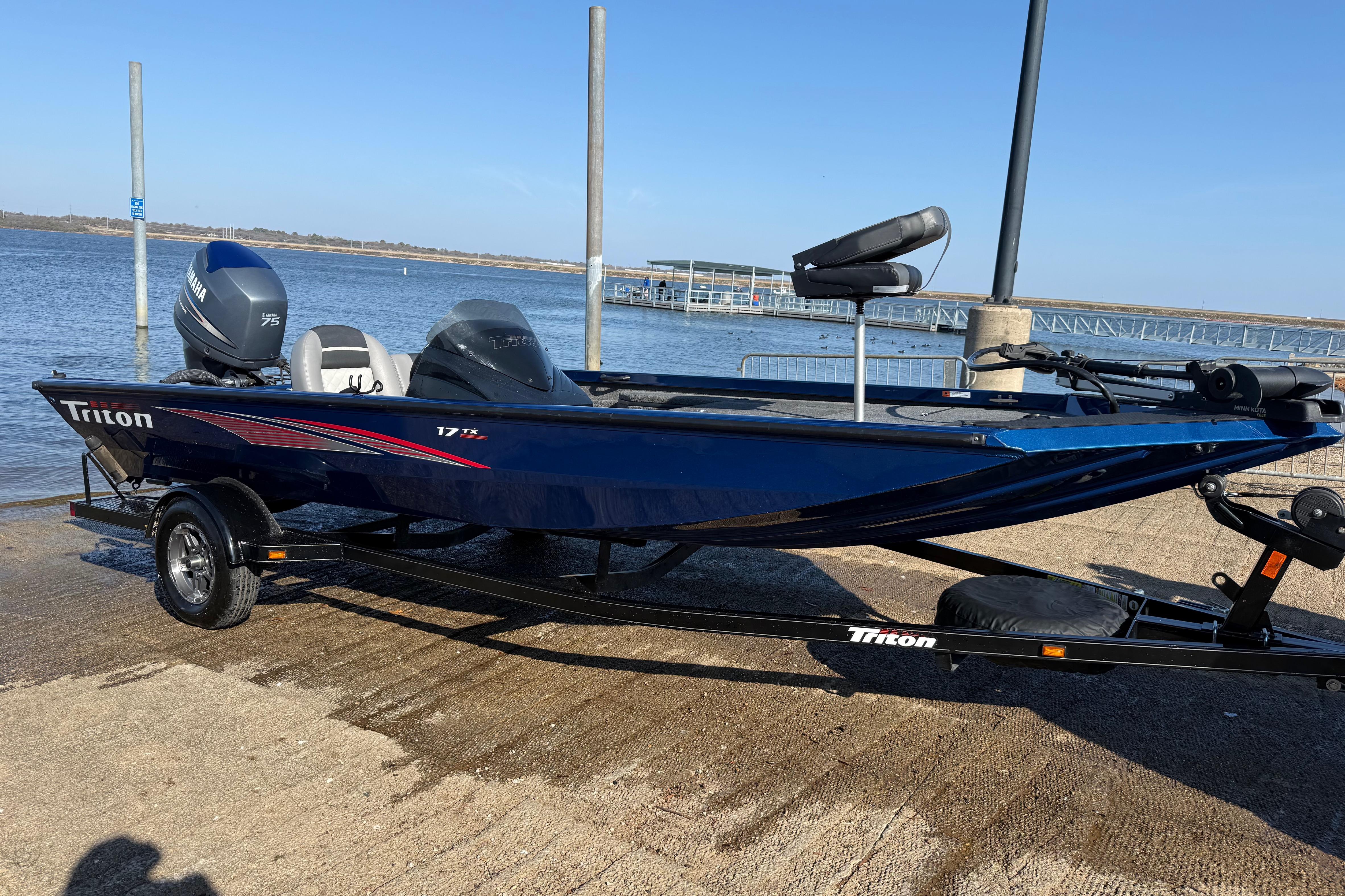2020 Triton 17 TX boat on trailer by the water, featuring Yamaha engine.
