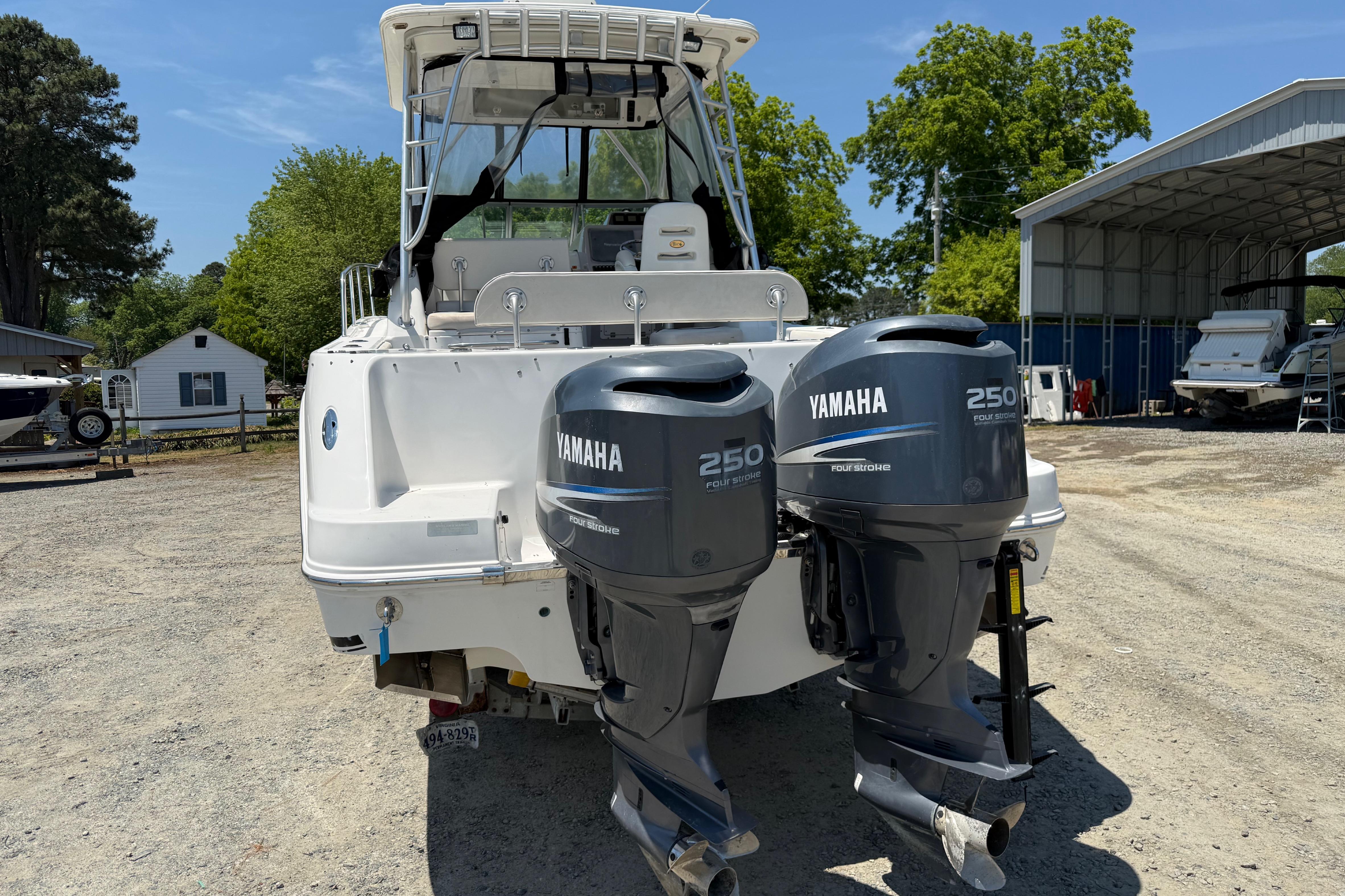 2007 Robalo R305 Walkaround boat with twin Yamaha 250 engines, parked outdoors.