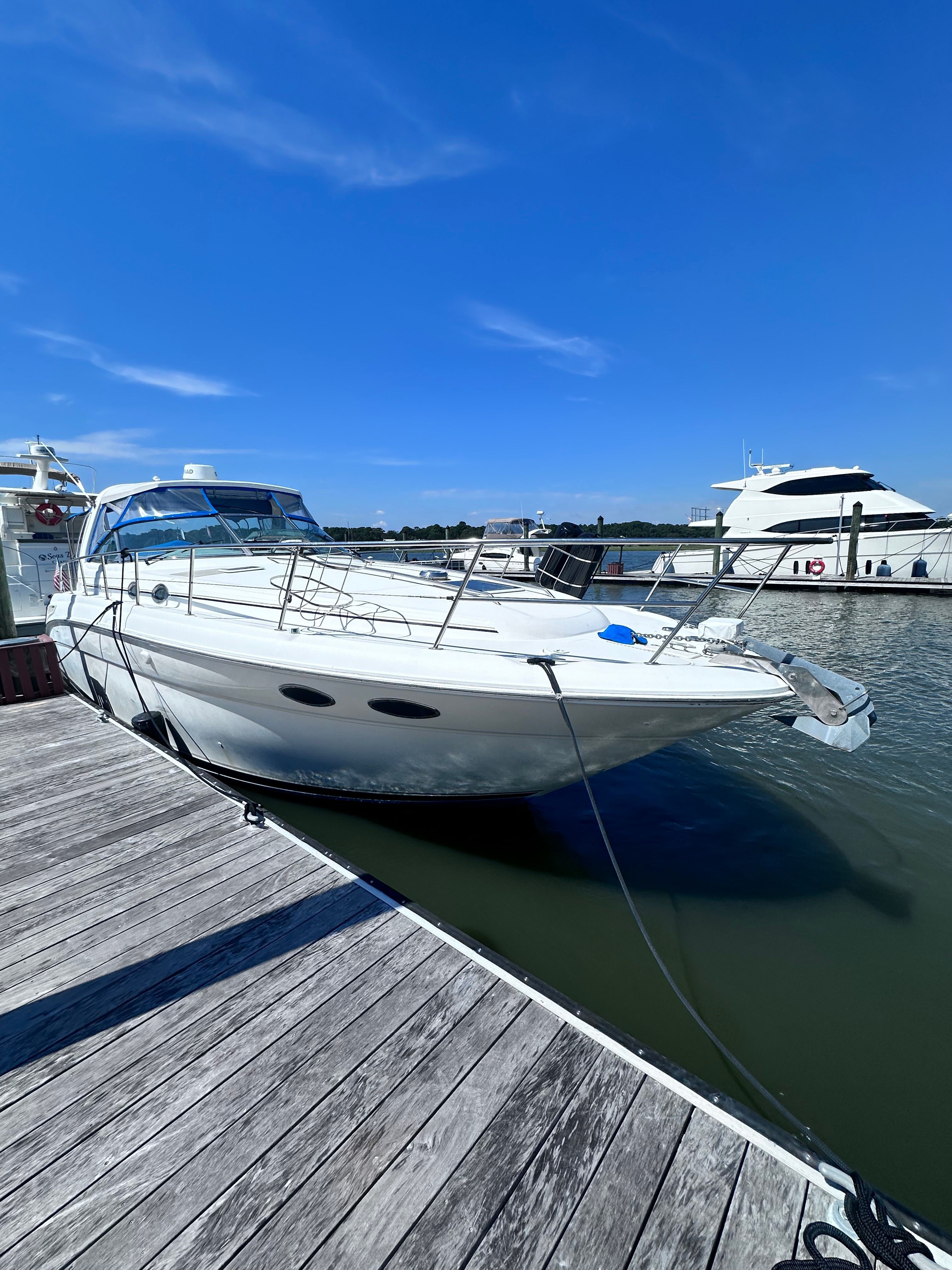 2000 Sea Ray 380 Sundancer yacht docked at marina under clear blue sky.