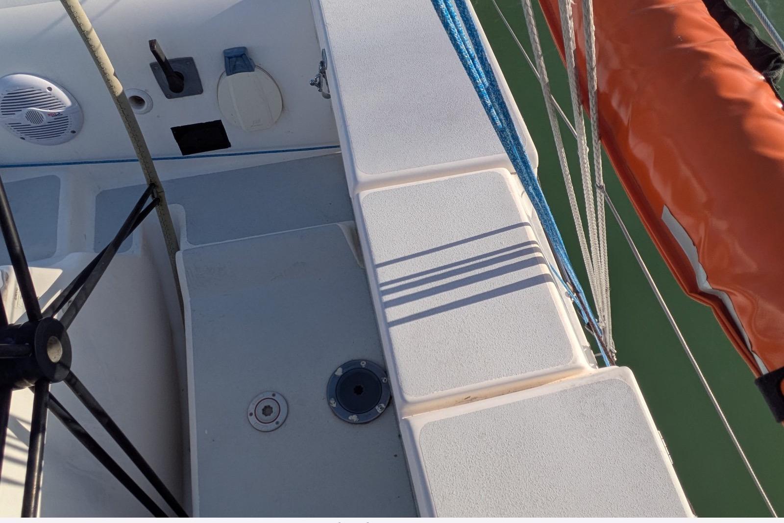 Deck view of a 2008 JPK 110 sailboat with ropes and orange sail.