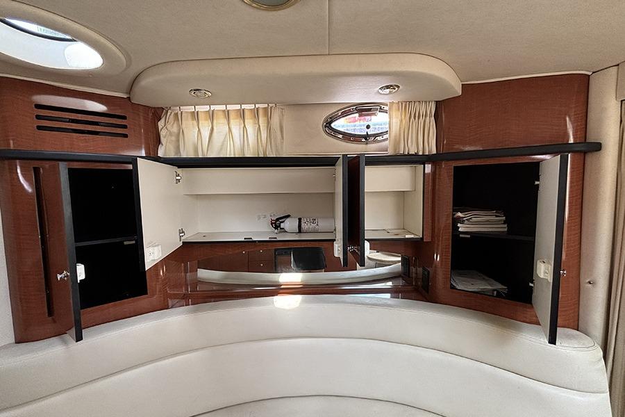 Interior of 2002 Sea Ray Sundancer 320 with open cabinets and porthole window.