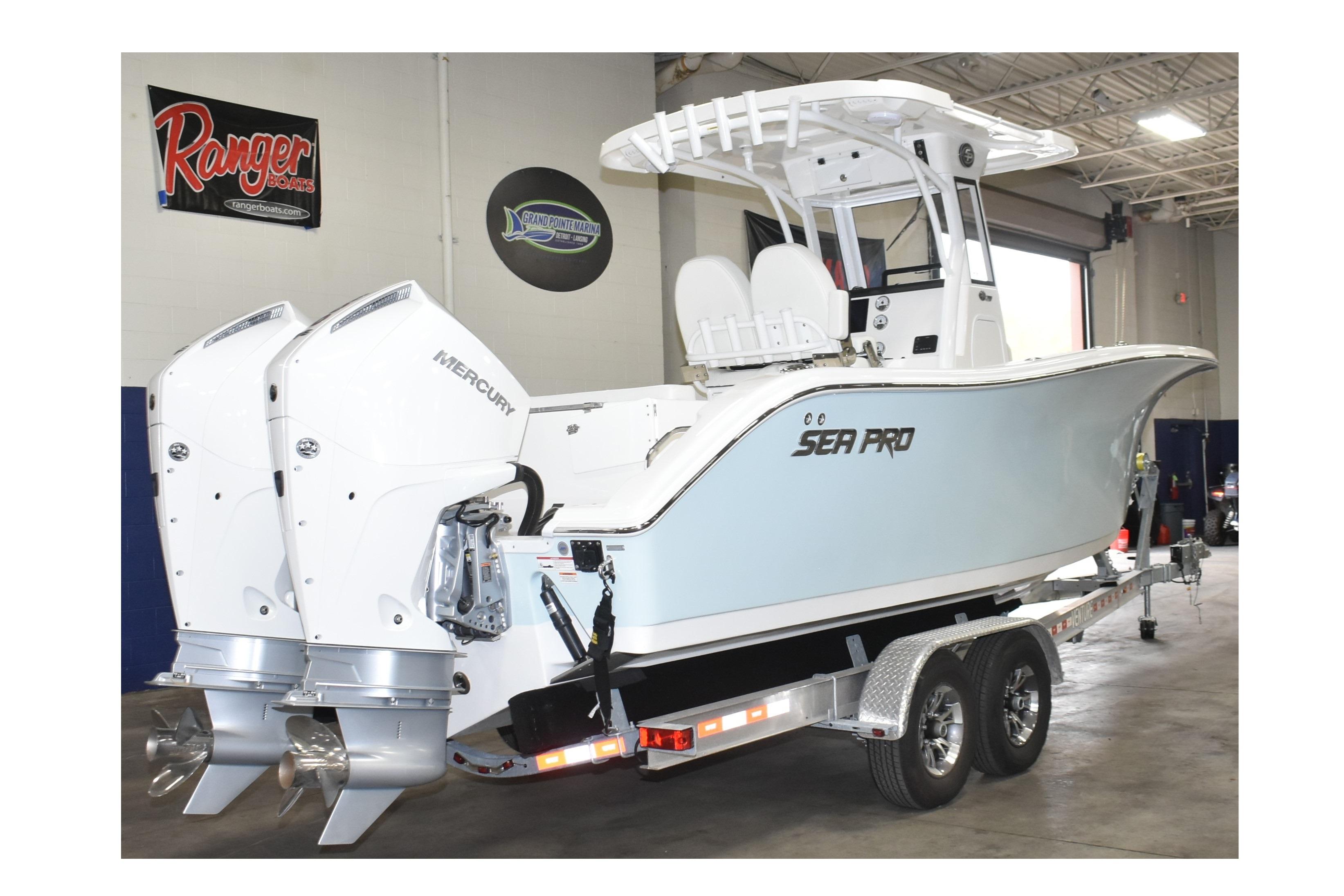 2025 Sea Pro 262 Offshore boat with dual Mercury engines on trailer in showroom.