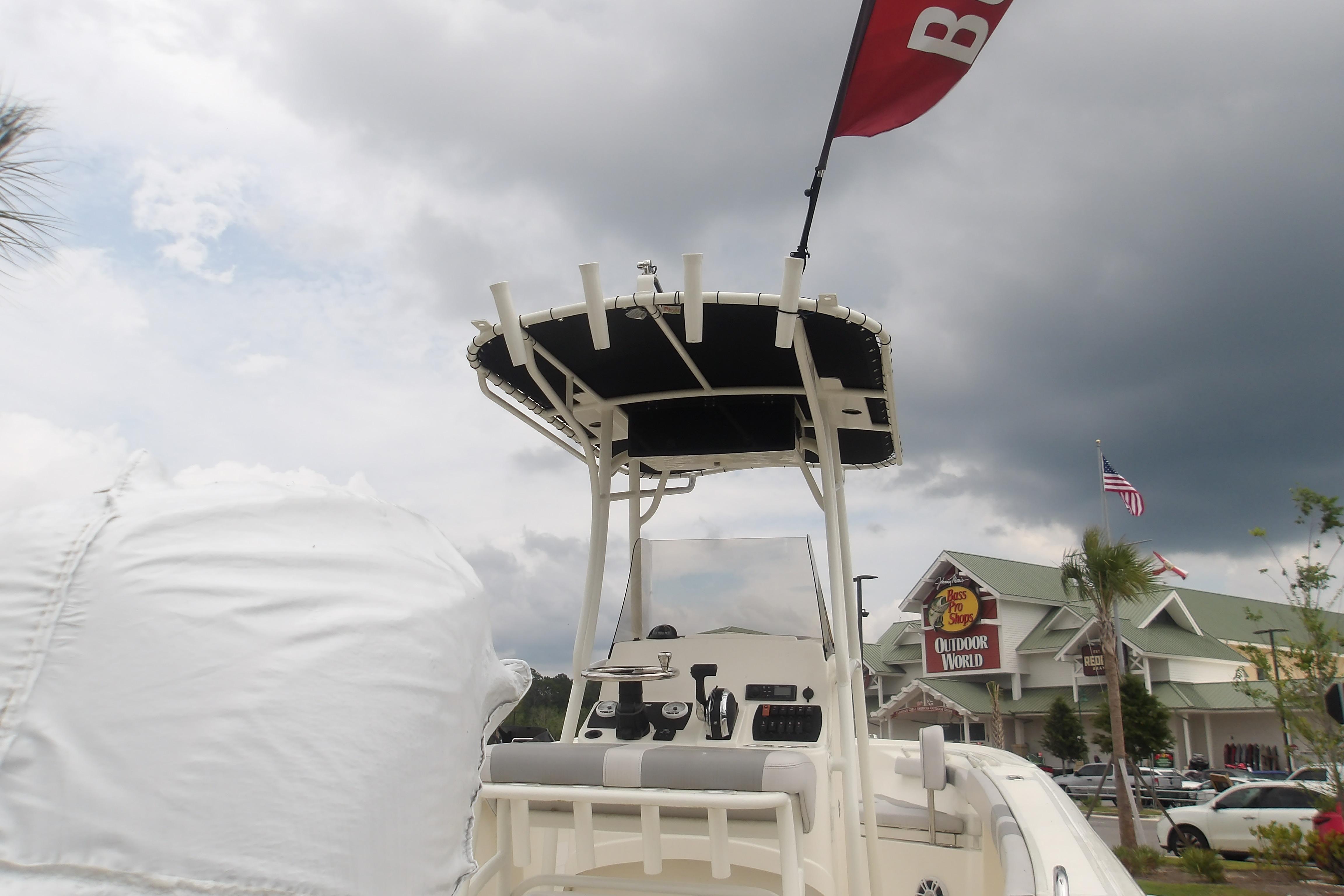 2025 Mako 214 Center Console boat at outdoor store, cloudy sky background.