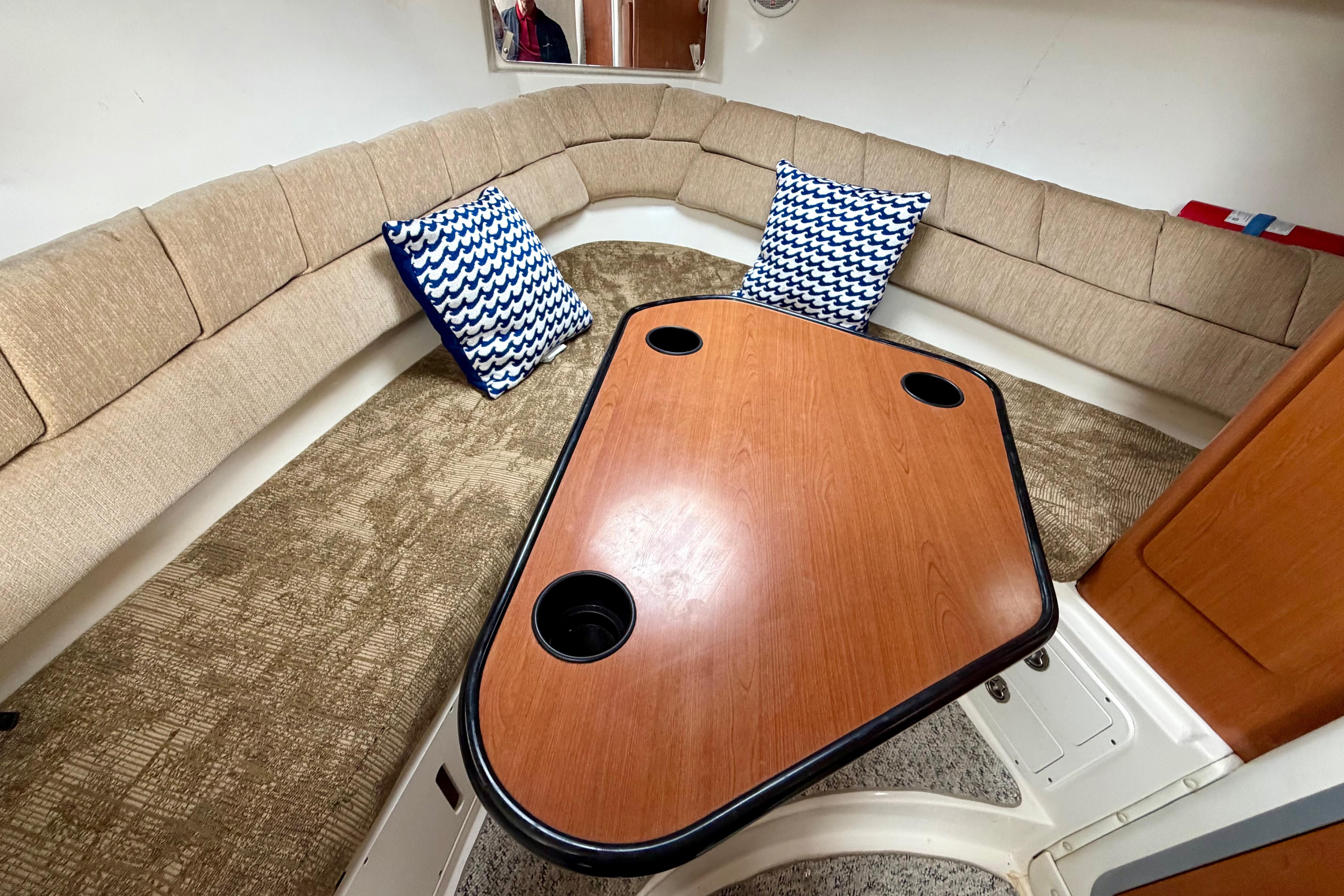 2006 Seaswirl Striper 2901 Walkaround O/B cabin with cushioned seating and wooden table.
