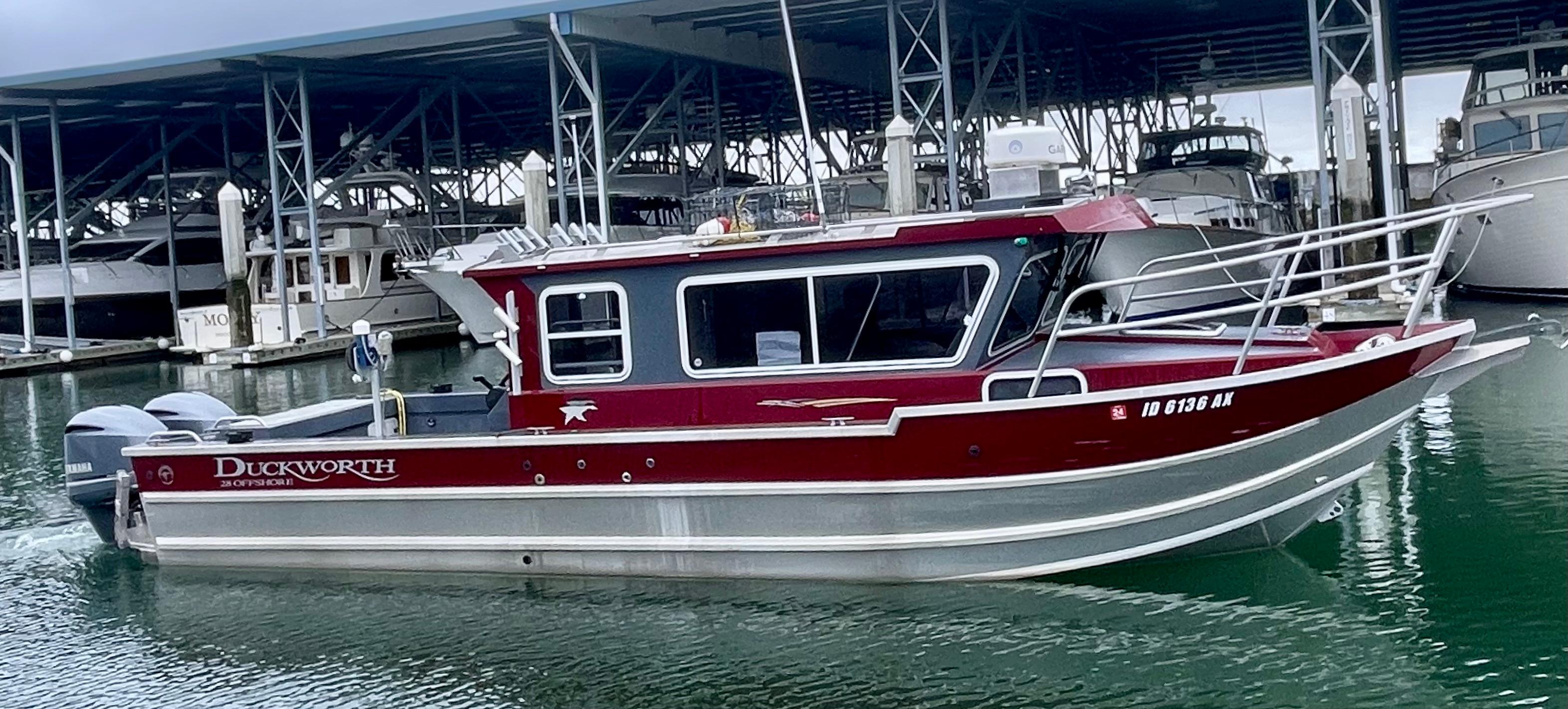 2018 Duckworth 28 Offshore boat docked in marina, featuring sleek red and silver design.