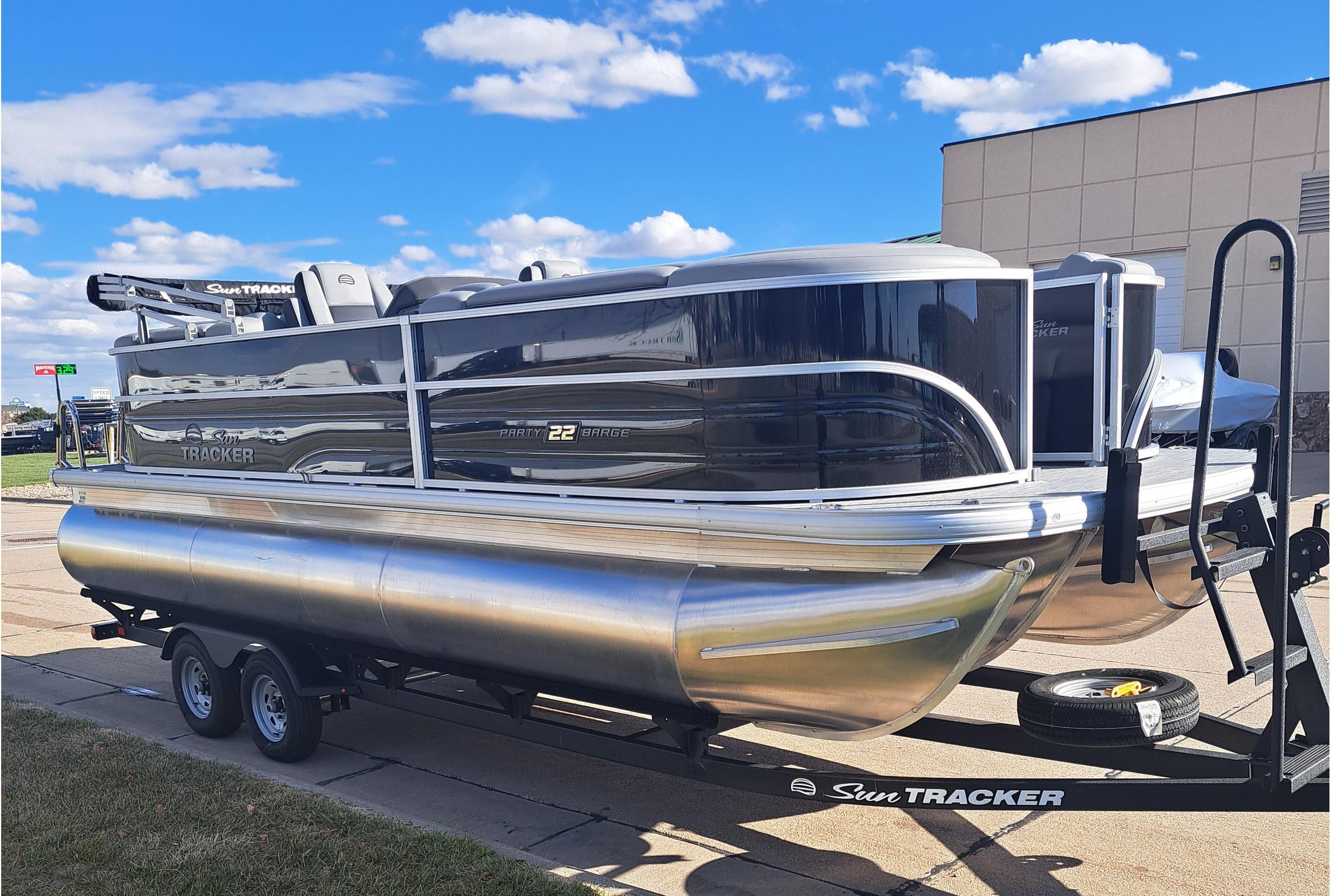 2026 Sun Tracker Party Barge 22 XP3 pontoon boat on trailer, parked outdoors.