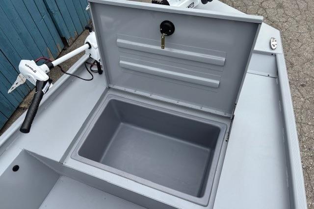 2026 Tracker Bass Tracker Classic CC boat storage compartment with open lid and trolling motor.