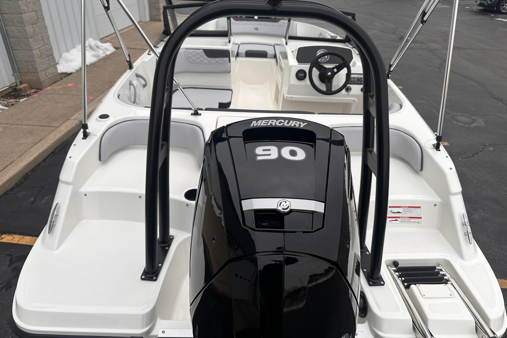 2026 Bayliner M17 boat with Mercury 90 engine, docked on pavement.