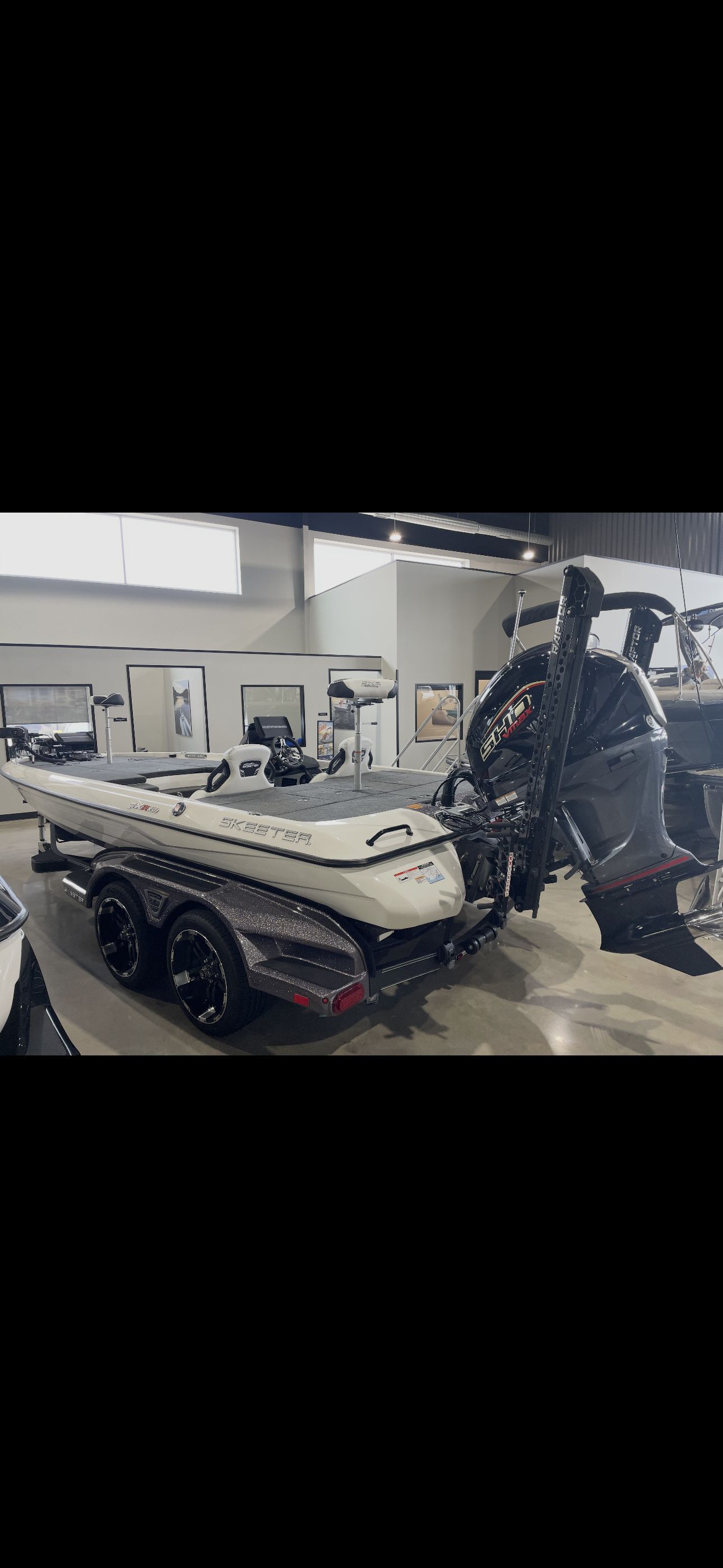 A 2022 Skeeter FXR20 Limited boat is on a trailer in a showroom.