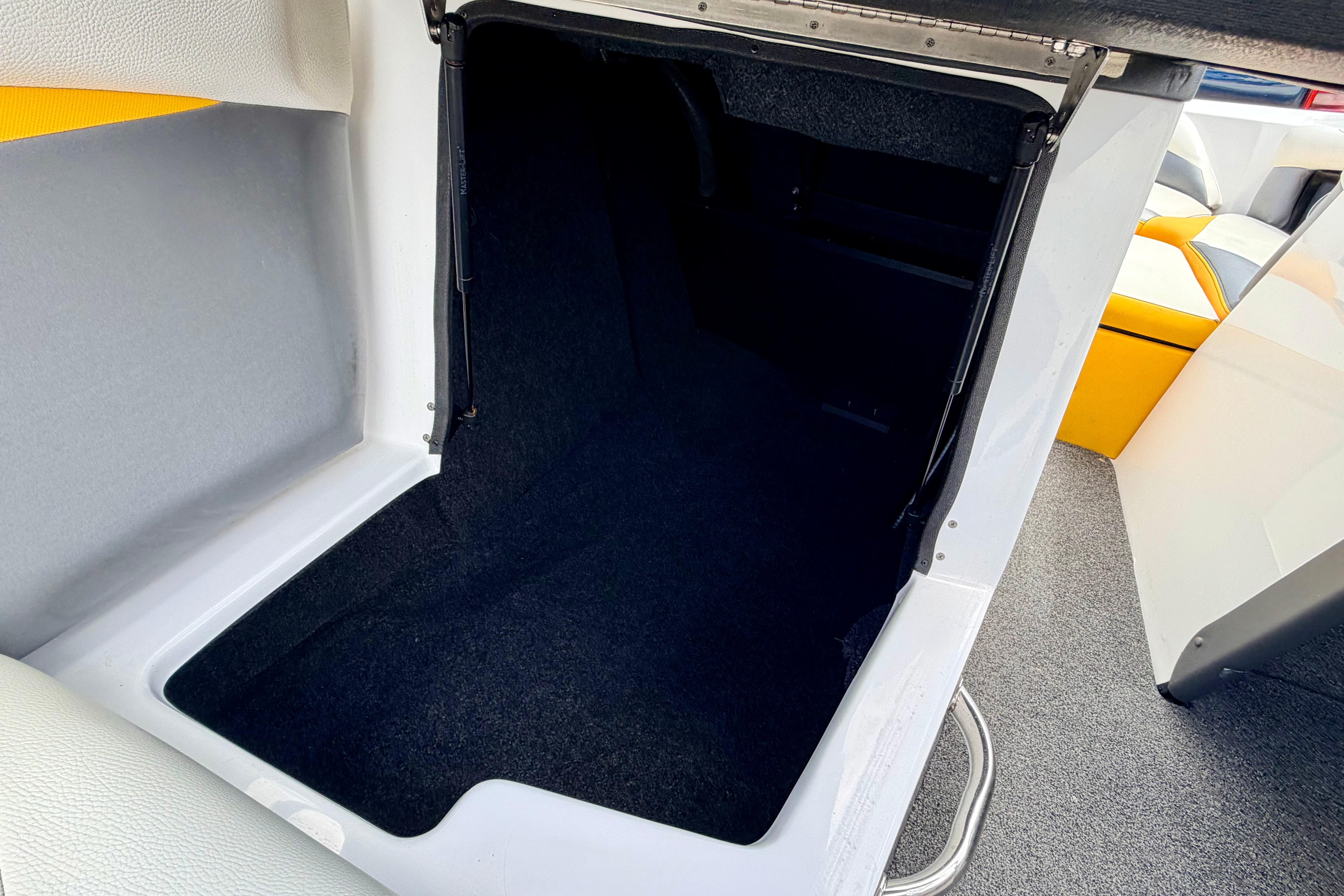 2014 Tigé R20 boat interior storage compartment with carpeted flooring.