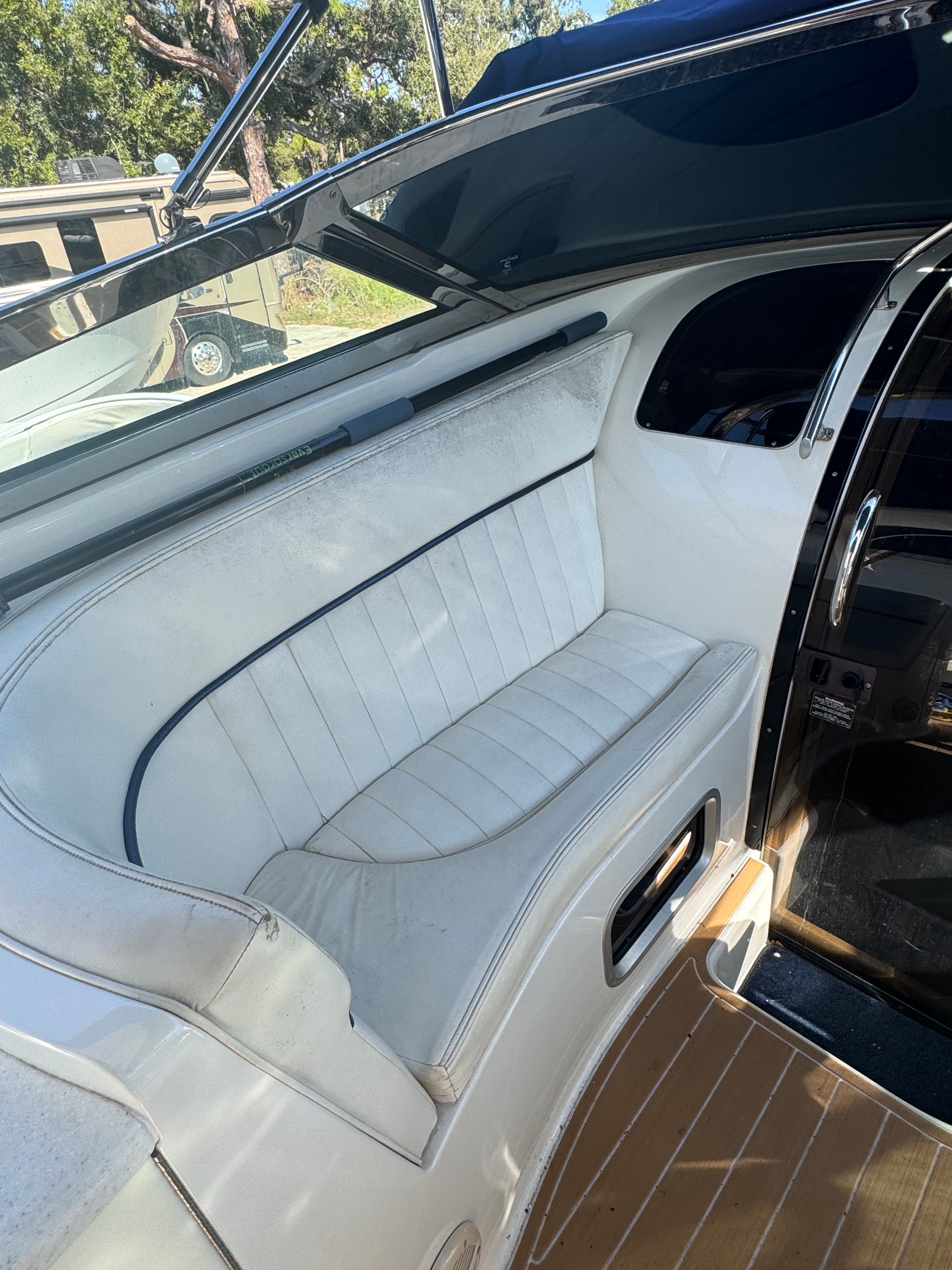 Interior of a 2003 Cobalt 360 with white seating and wooden flooring.