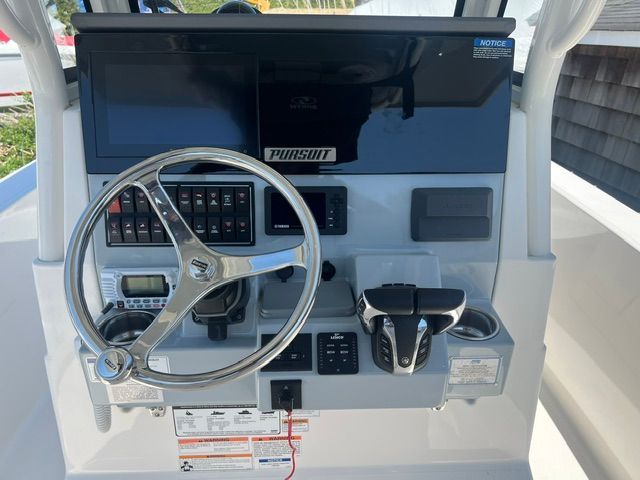 The image shows the helm of a 2023 Pursuit S268 boat with a modern steering wheel and controls.