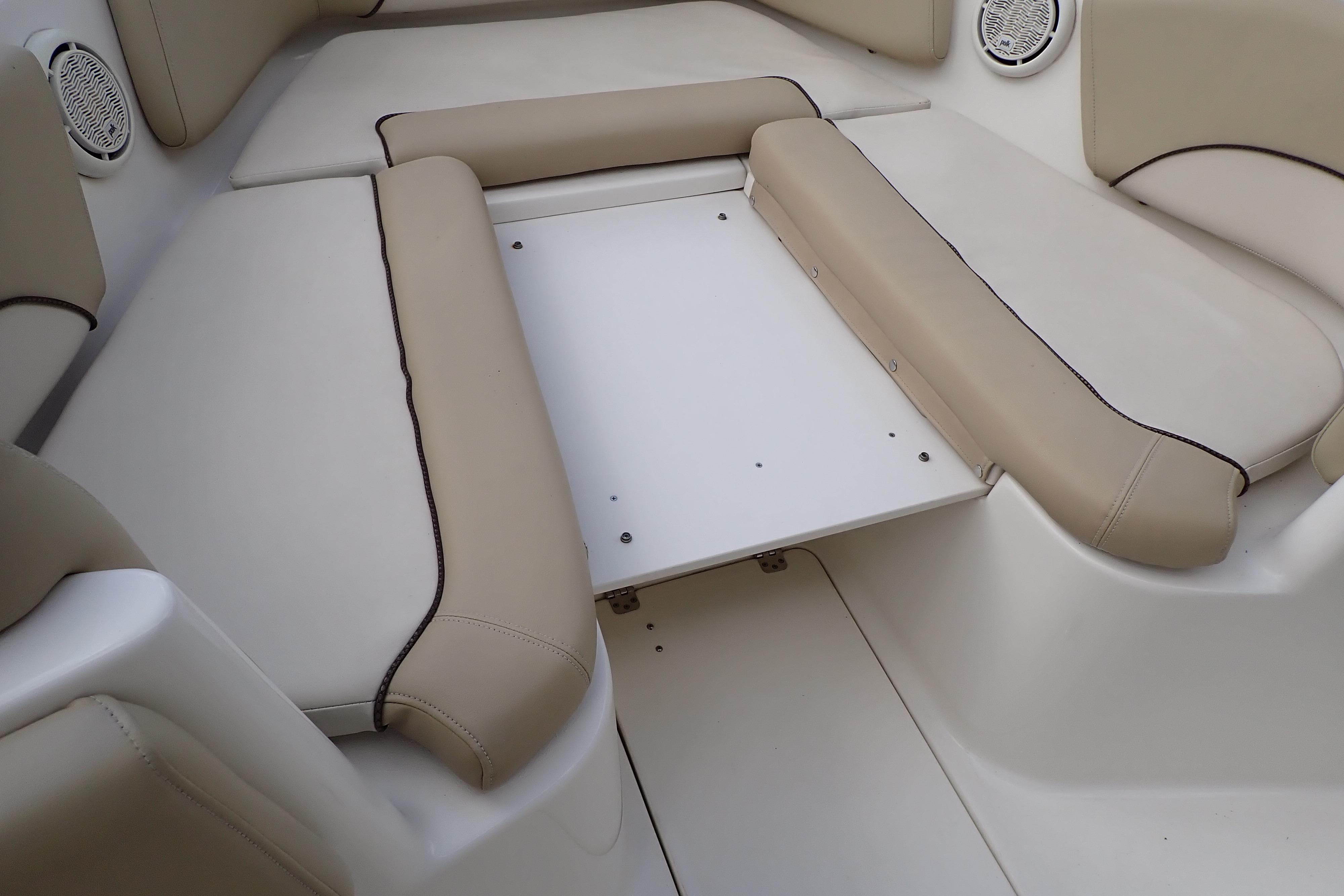 2019 Key West 263 FS boat interior with beige cushioned seating and white table.
