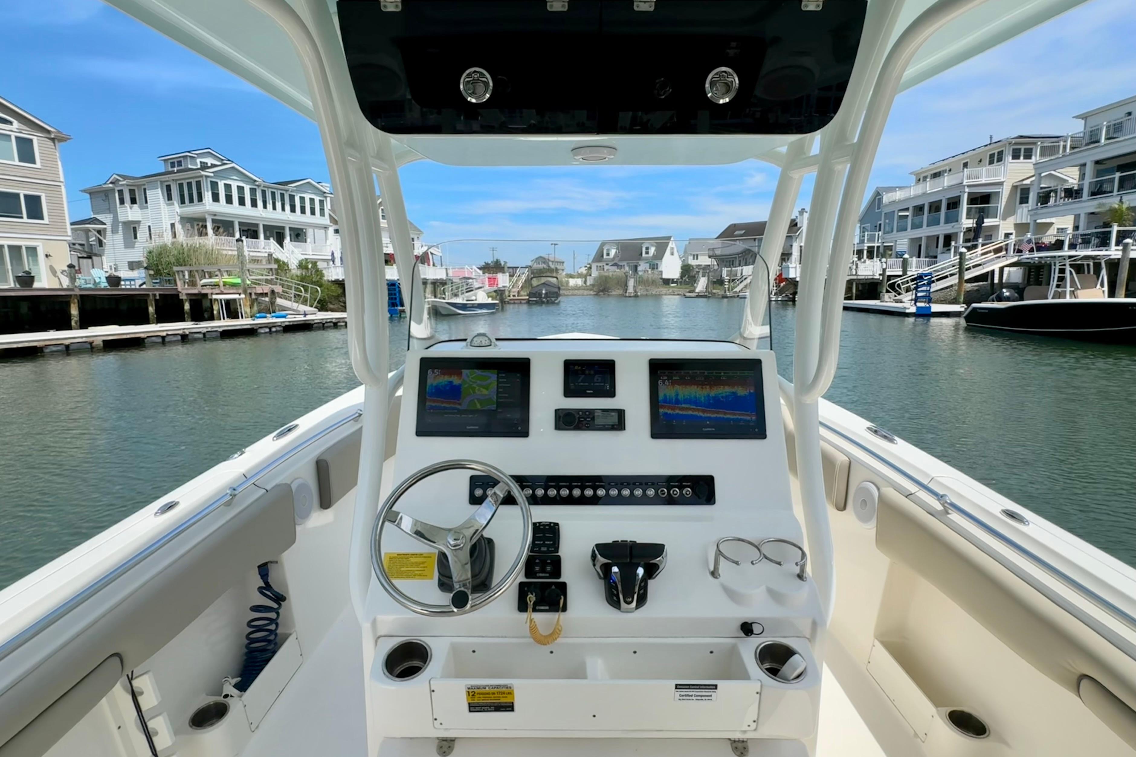 2022 Key West 263 FS boat dashboard with modern navigation equipment, docked in a scenic marina.