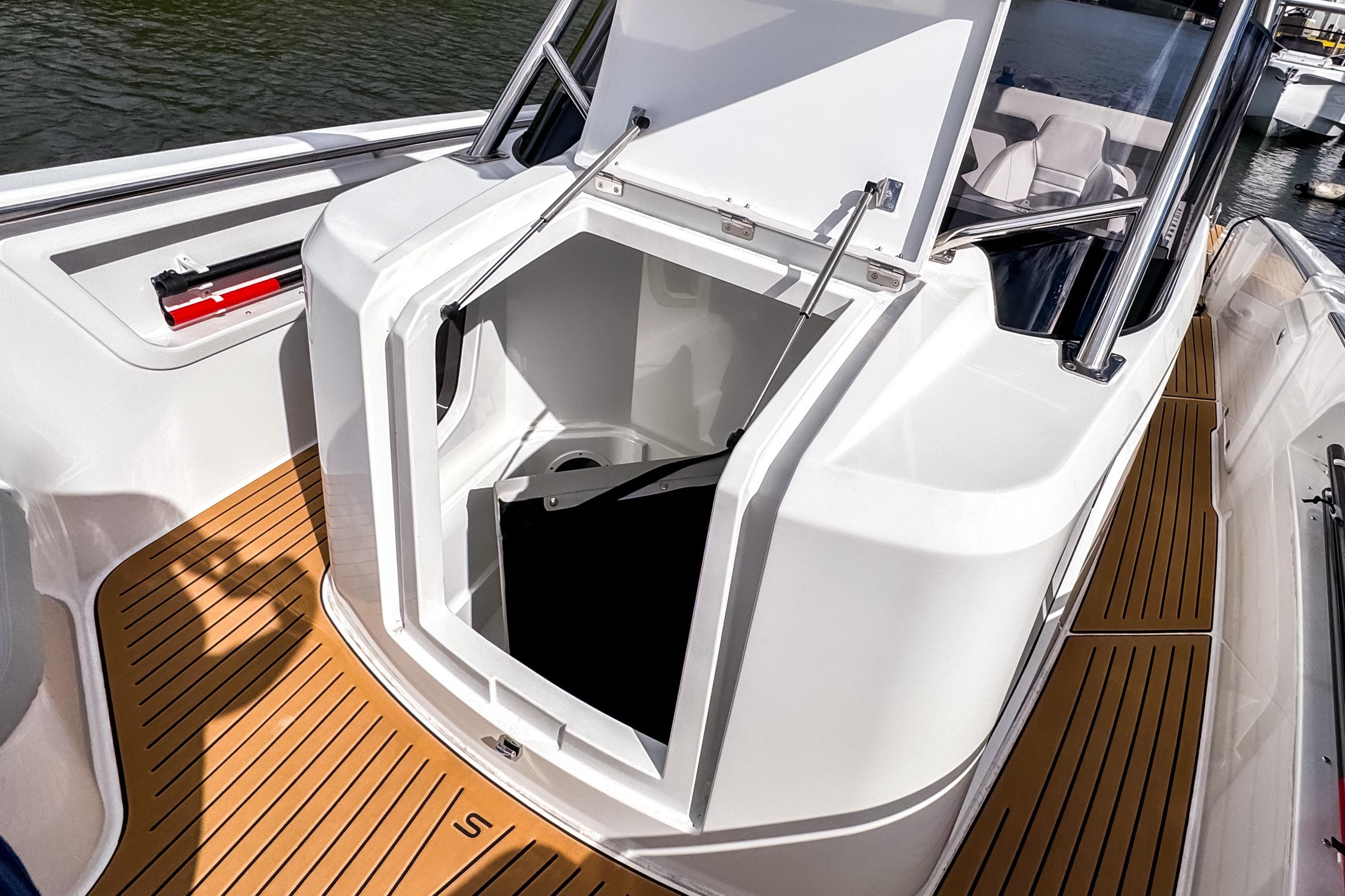 2025 STERK 31 boat with open storage compartment and teak flooring.