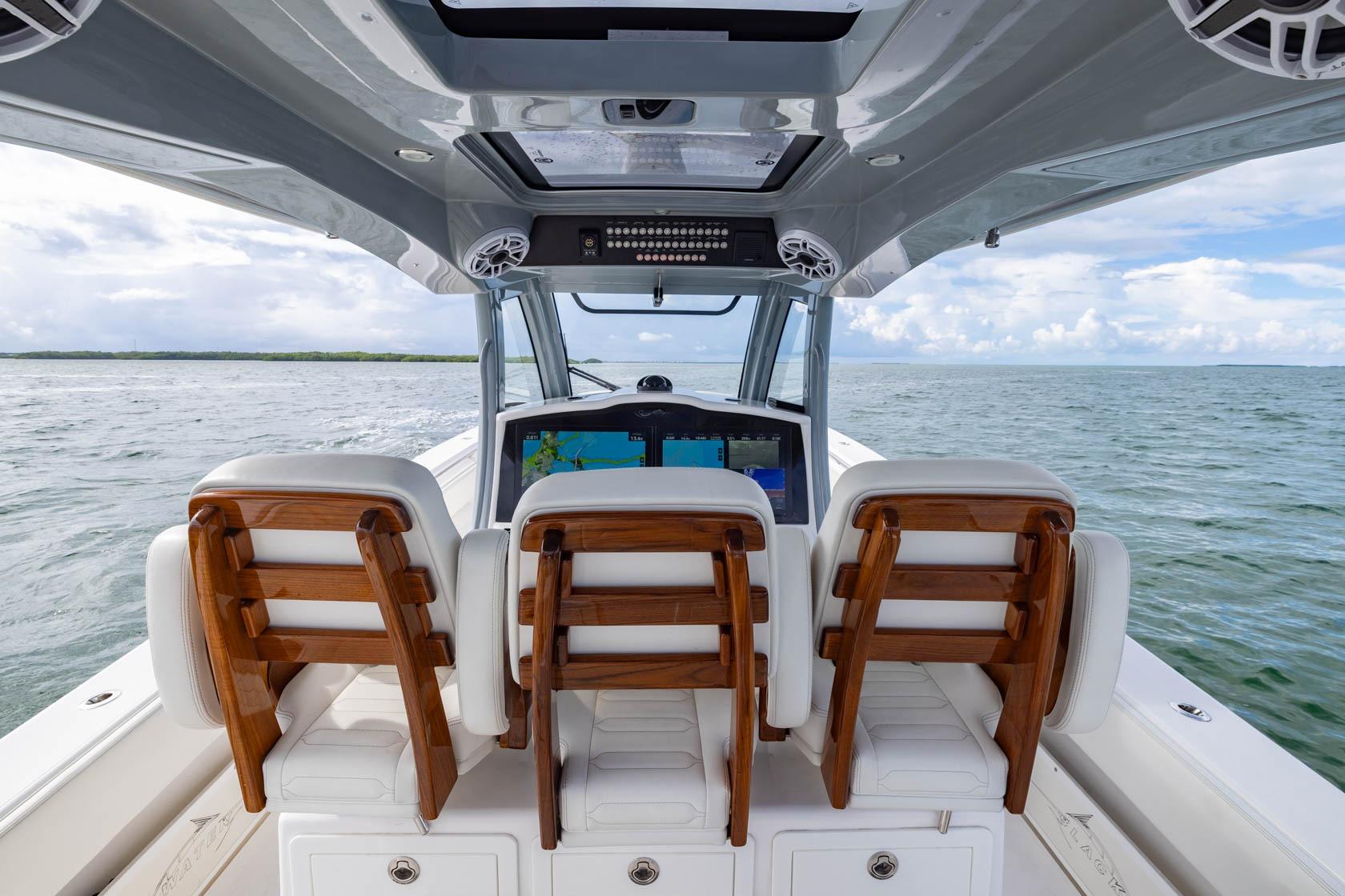2024 Blackwater 43 Sportfish boat interior with wooden seats, navigating open waters.
