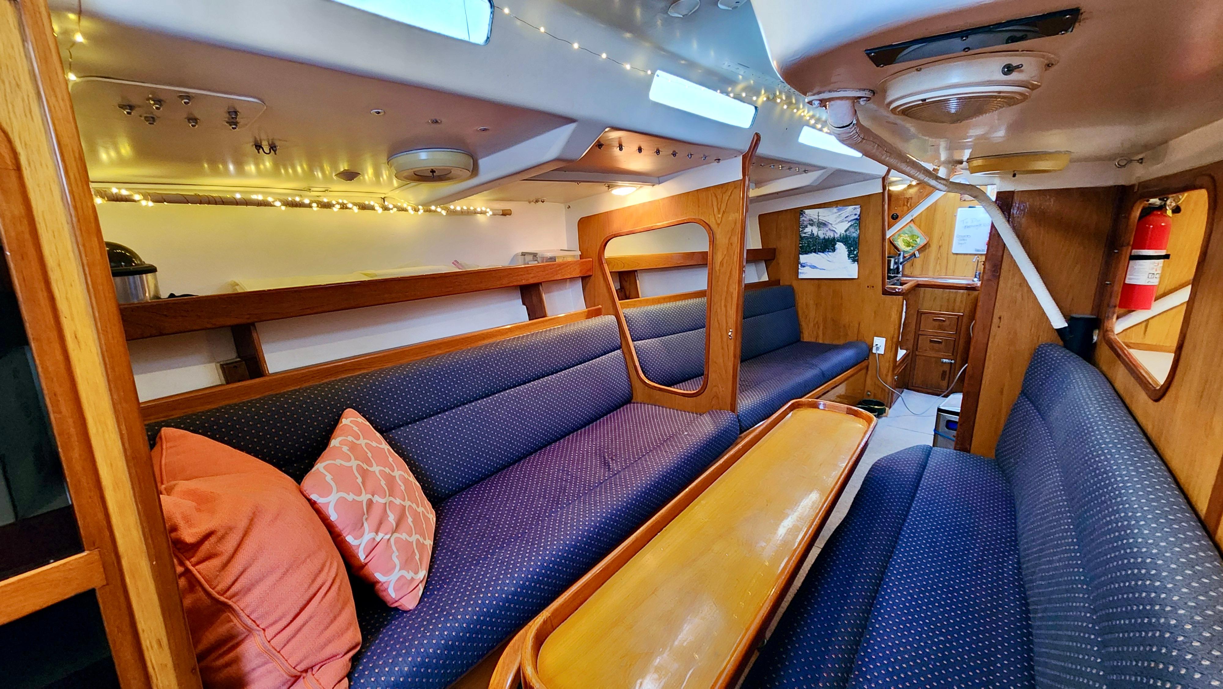 Interior of 1985 Farr 50 yacht with cozy seating and wooden accents.