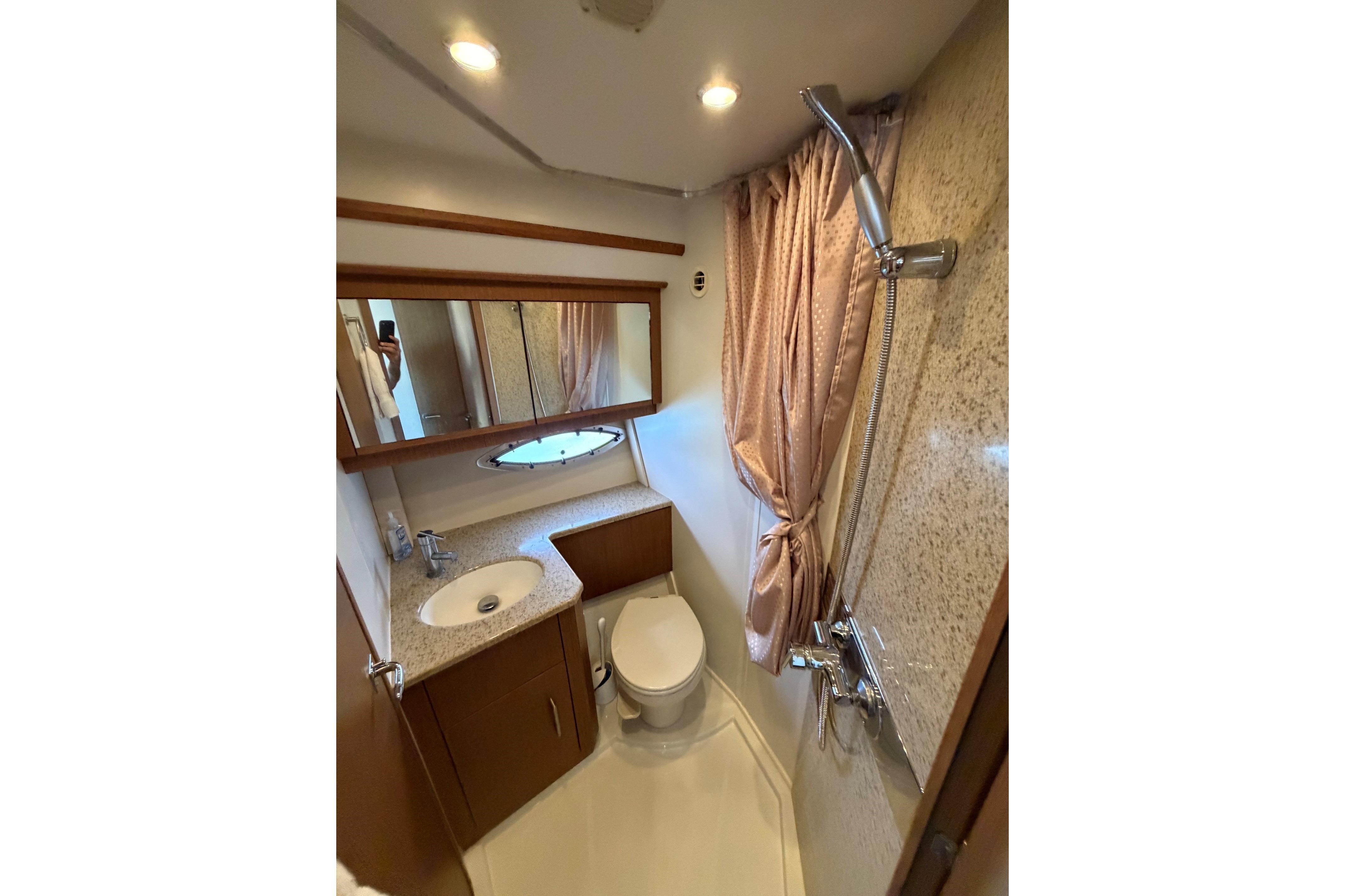 Luxurious bathroom in 2011 Carver 44 Sojourn yacht with shower, sink, and toilet.