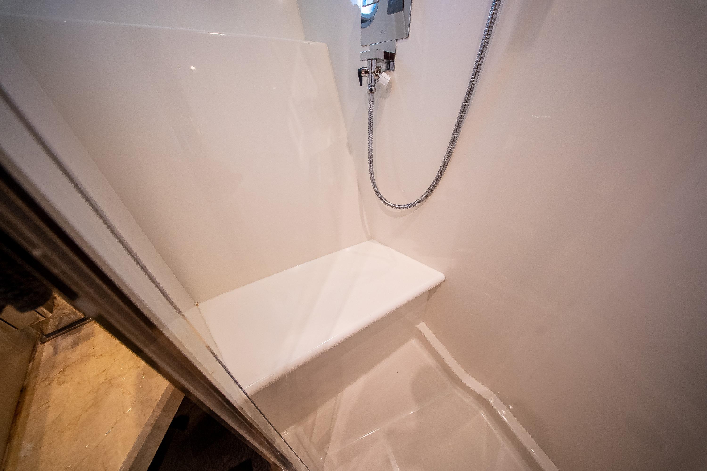 Shower area in 2012 Marquis 690 yacht with bench and handheld showerhead.