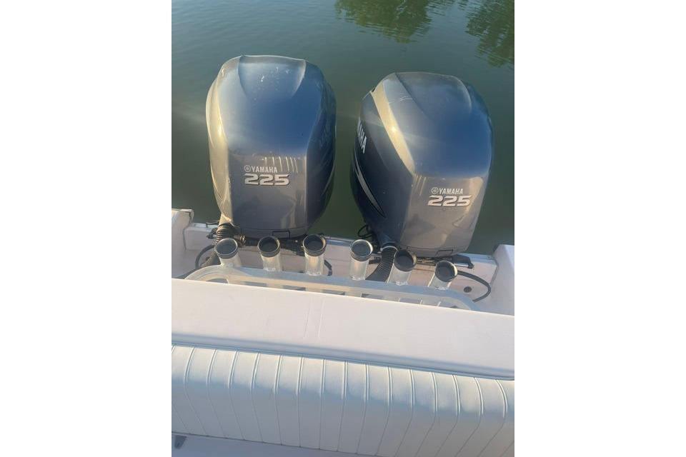 Twin Yamaha 225 engines on a 2002 Grady-White Marlin 300 boat, docked on calm water.